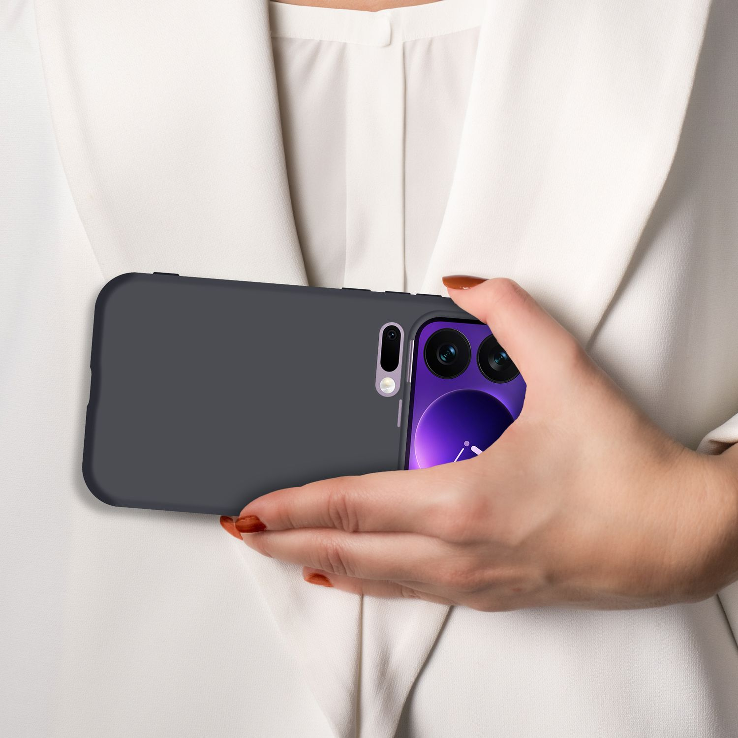 Eine Hand hält ein dunkles Smartphone mit violetter Anzeige vor einem weißen Hemd.