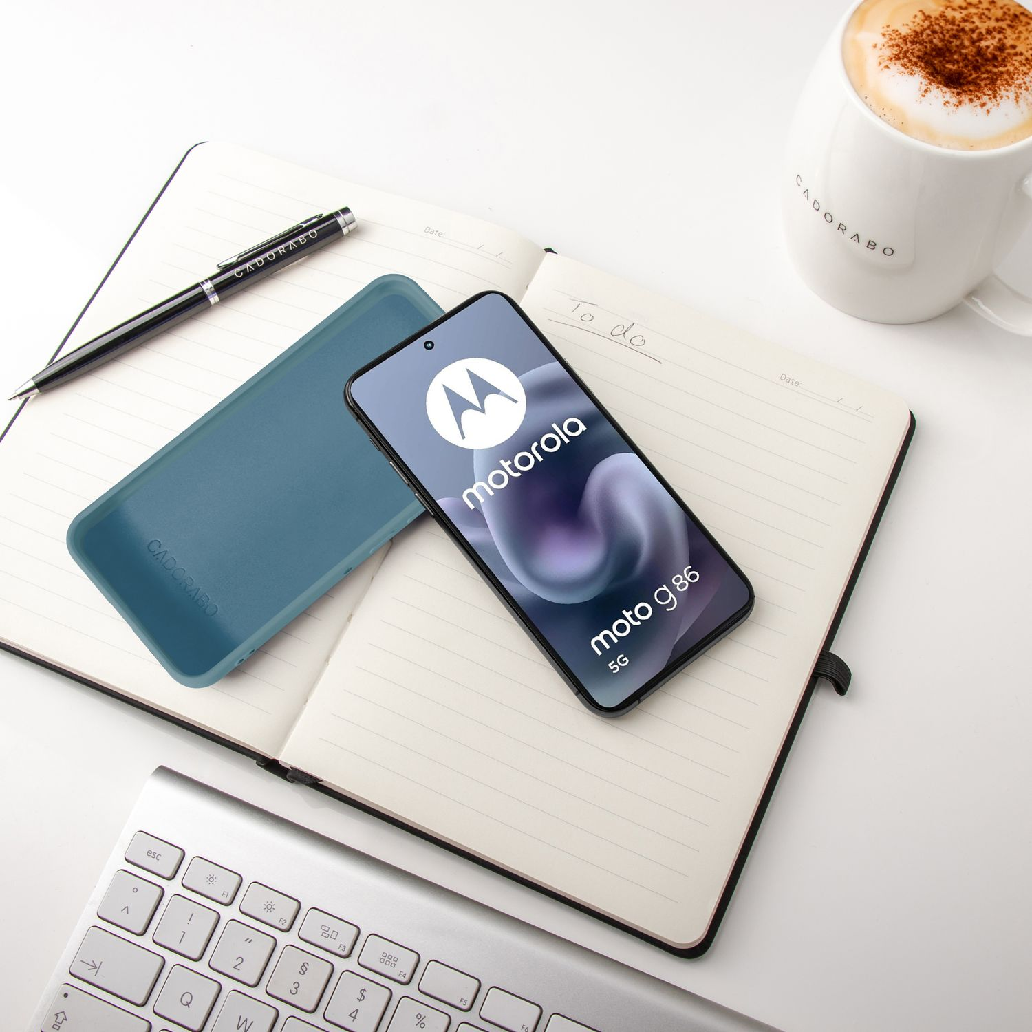 Ein Motorola-Smartphone liegt auf einem Notizbuch neben einer Kaffeetasse.