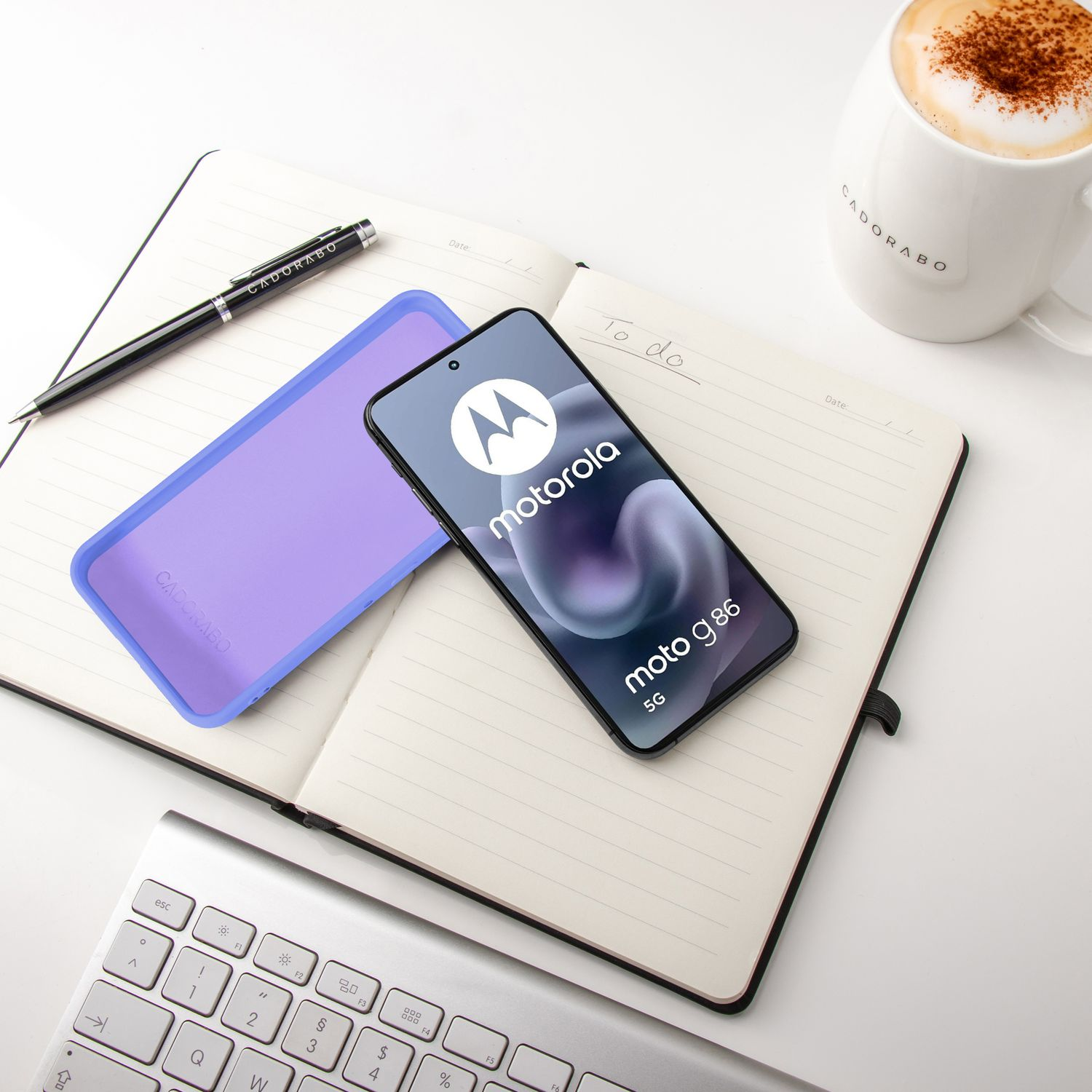 Ein Motorola-Smartphone liegt auf einem Notizbuch neben einer Kaffeetasse.