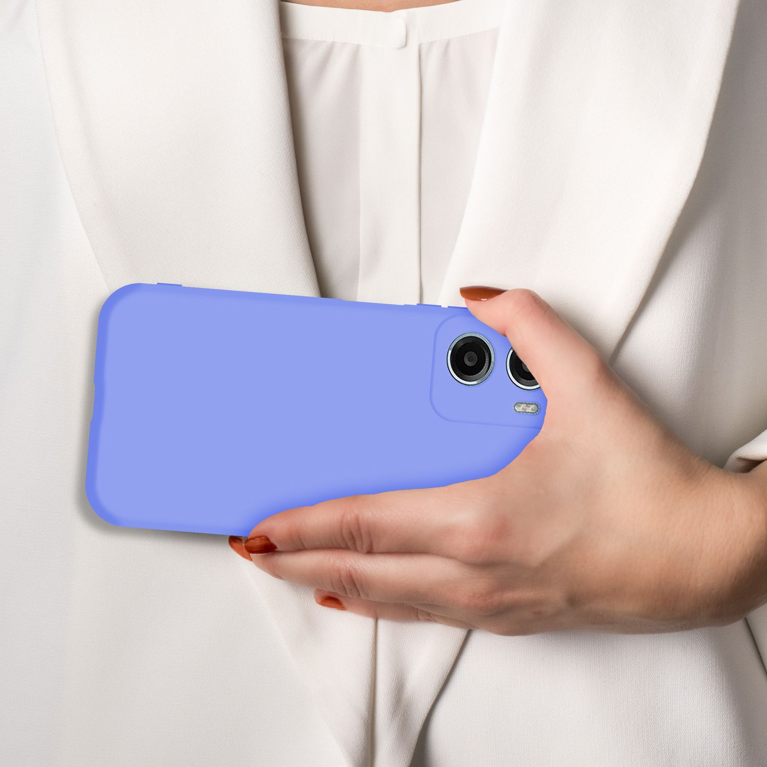 Eine Hand hält ein lila Smartphone vor einem weißen Hemd.