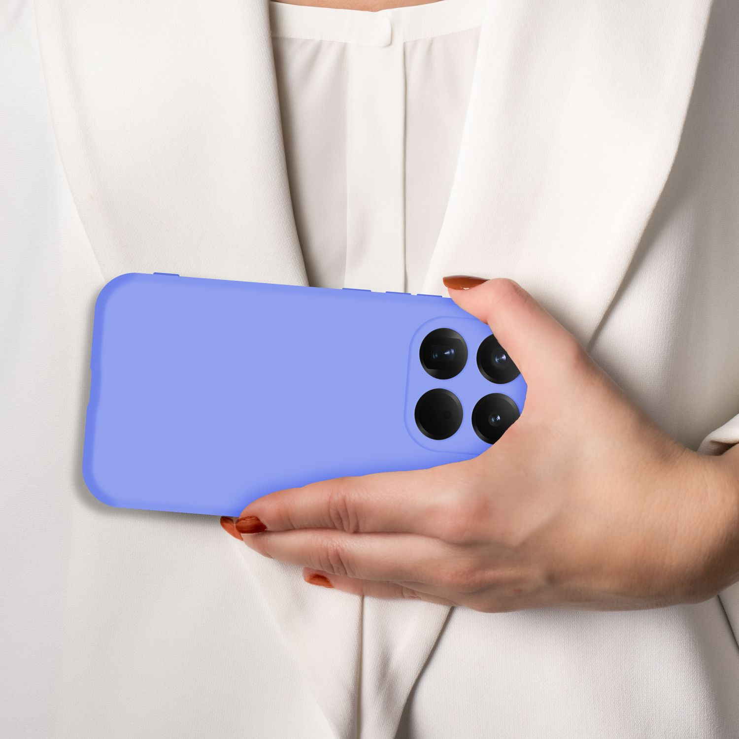 Eine Hand hält ein hellblaues Smartphone mit vier Kameras vor einem weißen Blazer.