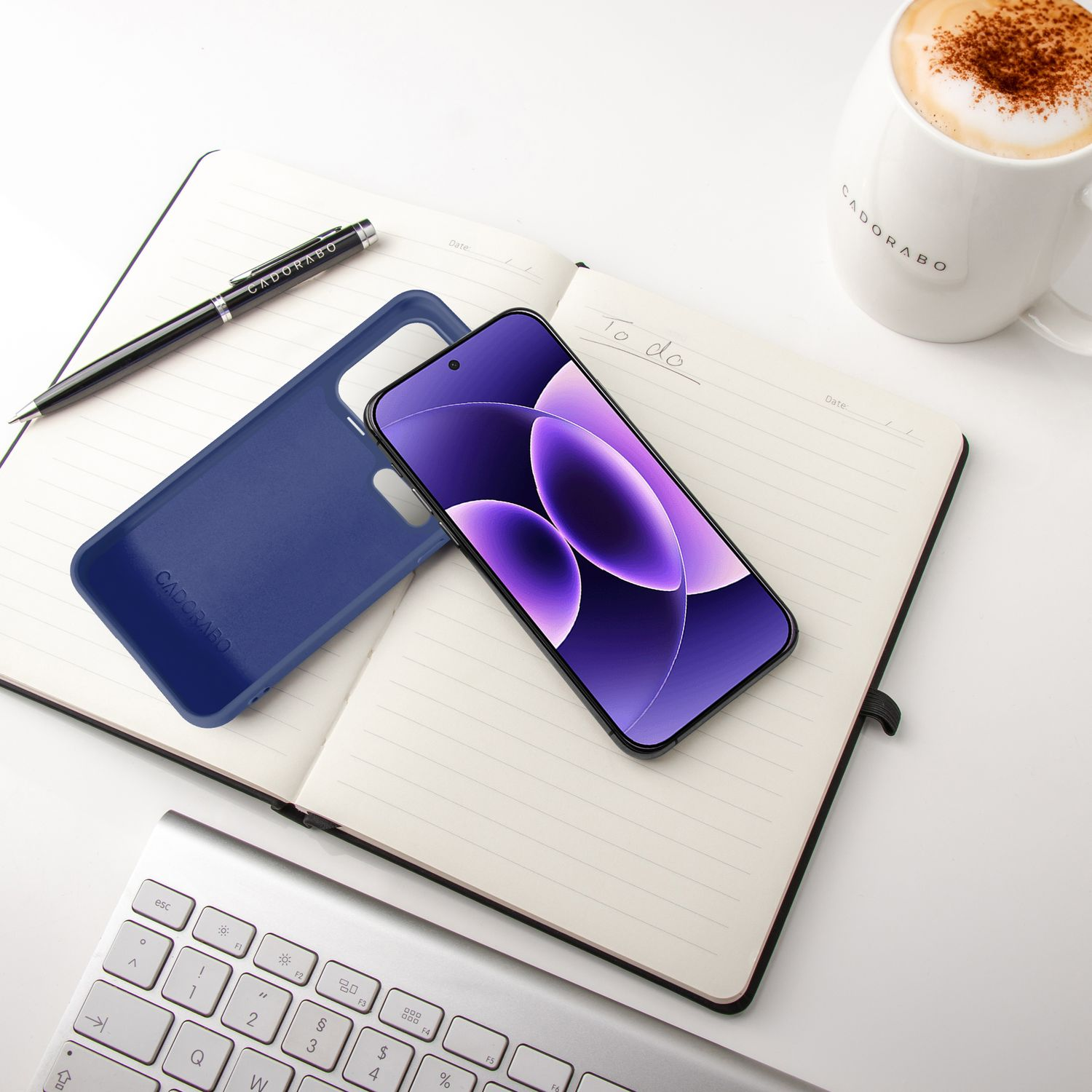 Ein Smartphone mit lila Hintergrund liegt auf einem Notizbuch neben einer blauen Hülle.