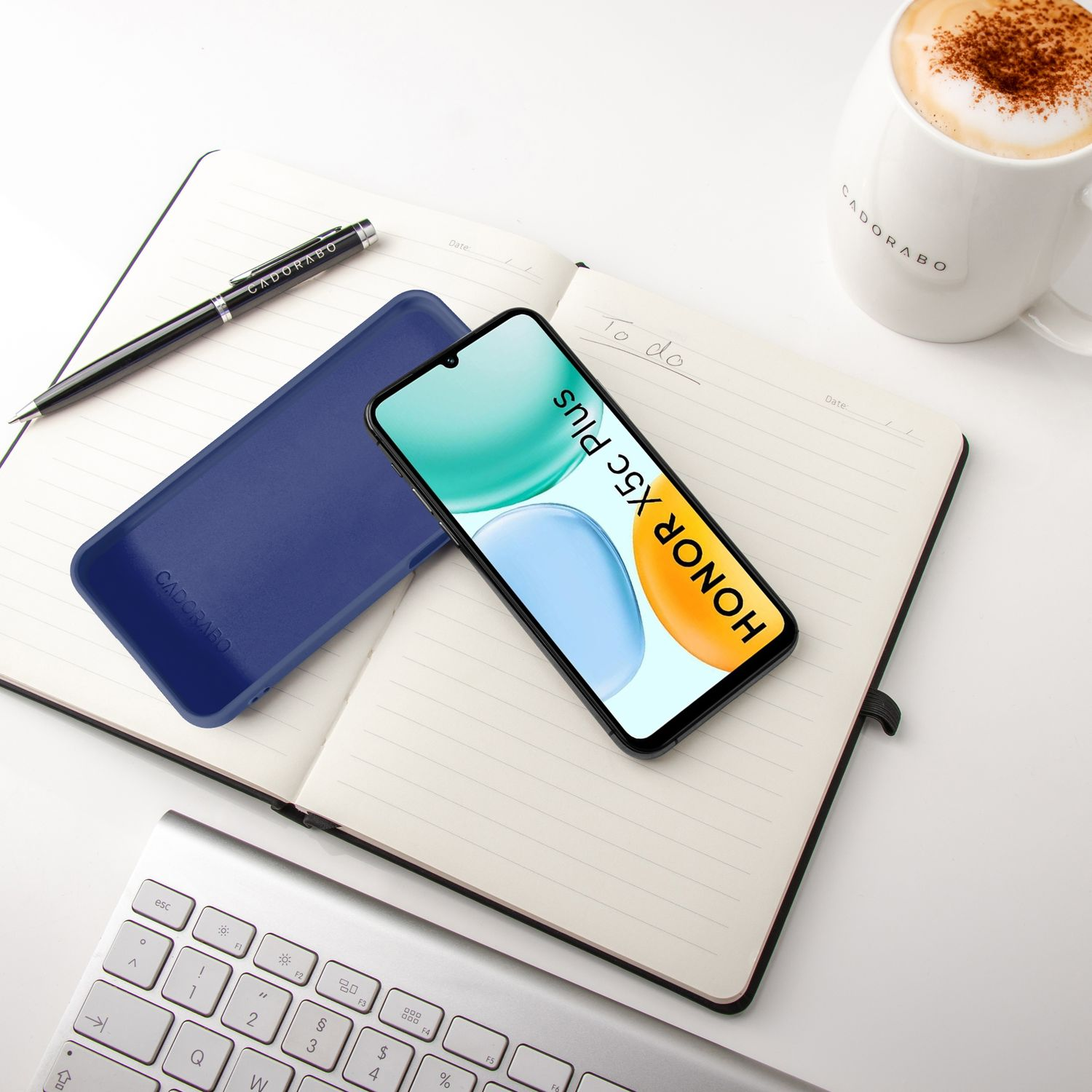 Ein Smartphone mit dem Schriftzug HONOR X5c Plus liegt auf einem Notizbuch.