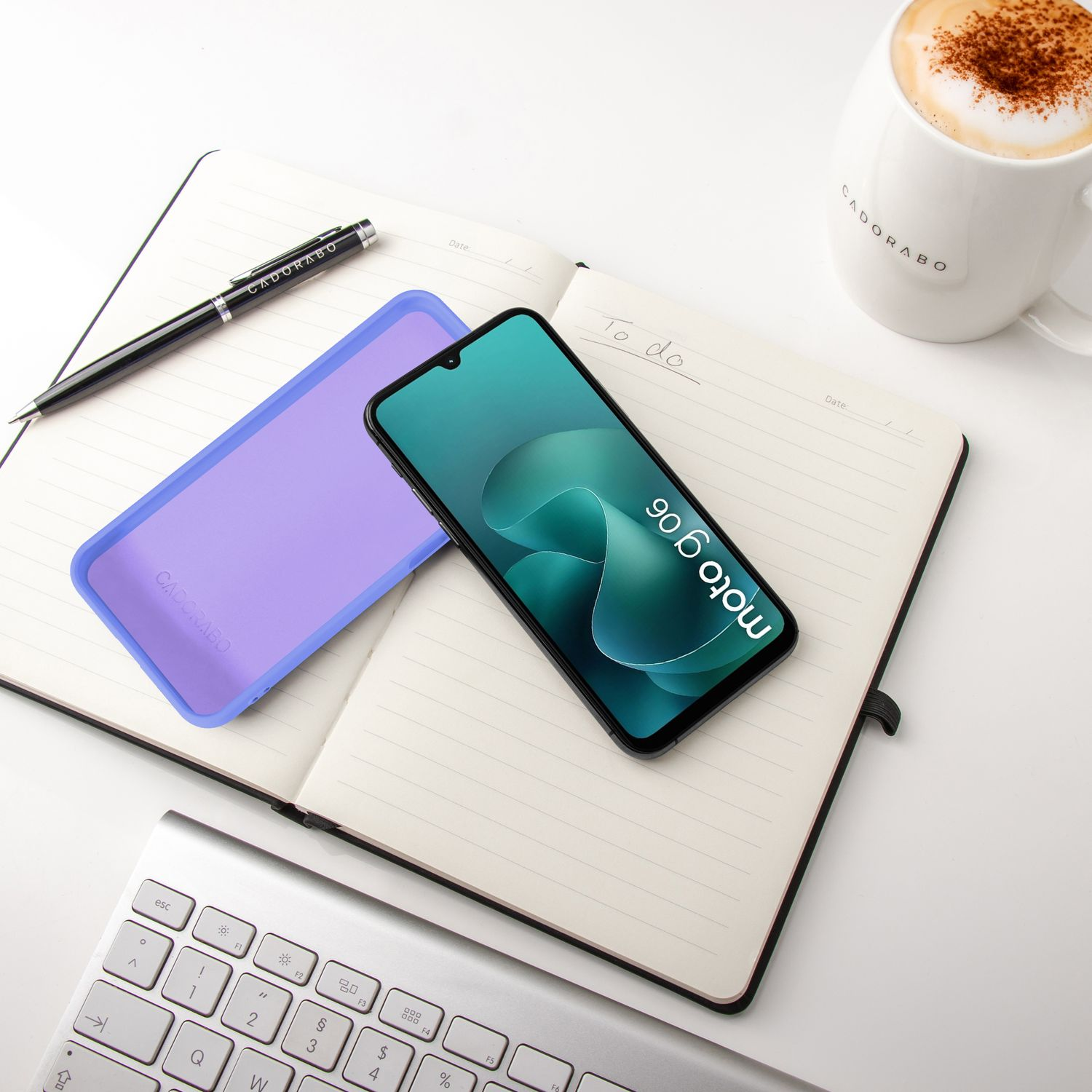 Ein offenes Notizbuch mit Stift, Handyhülle, Smartphone und Kaffee.