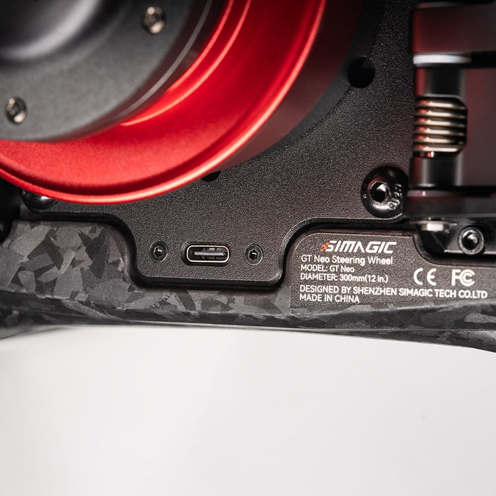 Nahaufnahme eines Lenkrads mit USB-C-Anschluss und roten Akzenten.