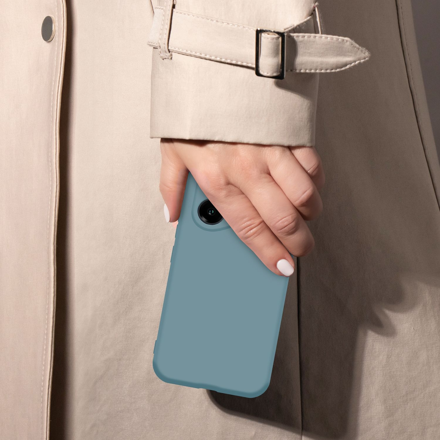 Eine Hand hält ein blaues Smartphone vor einem beigen Trenchcoat.