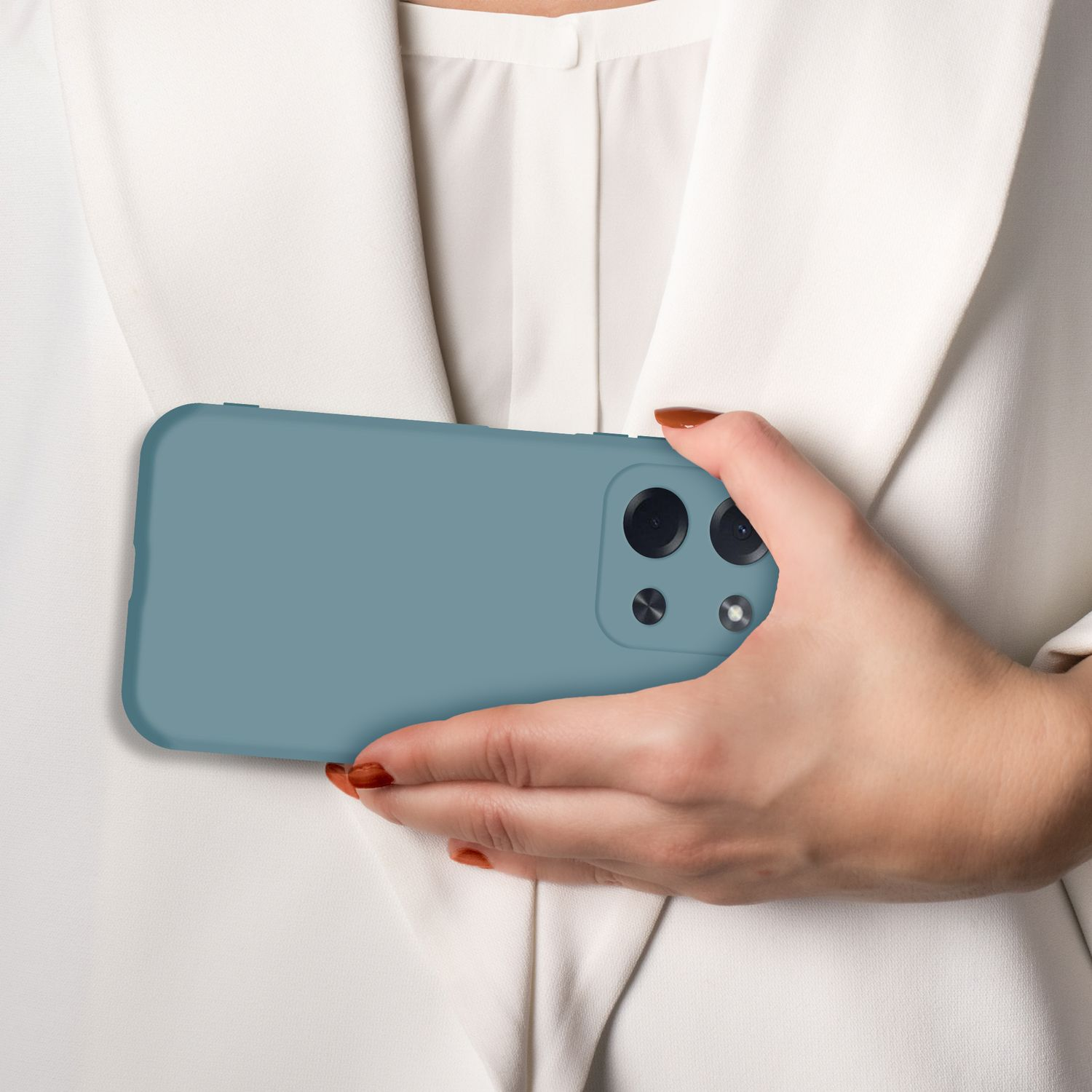 Eine Hand hält ein blaues Handy vor einem weißen Hemd.