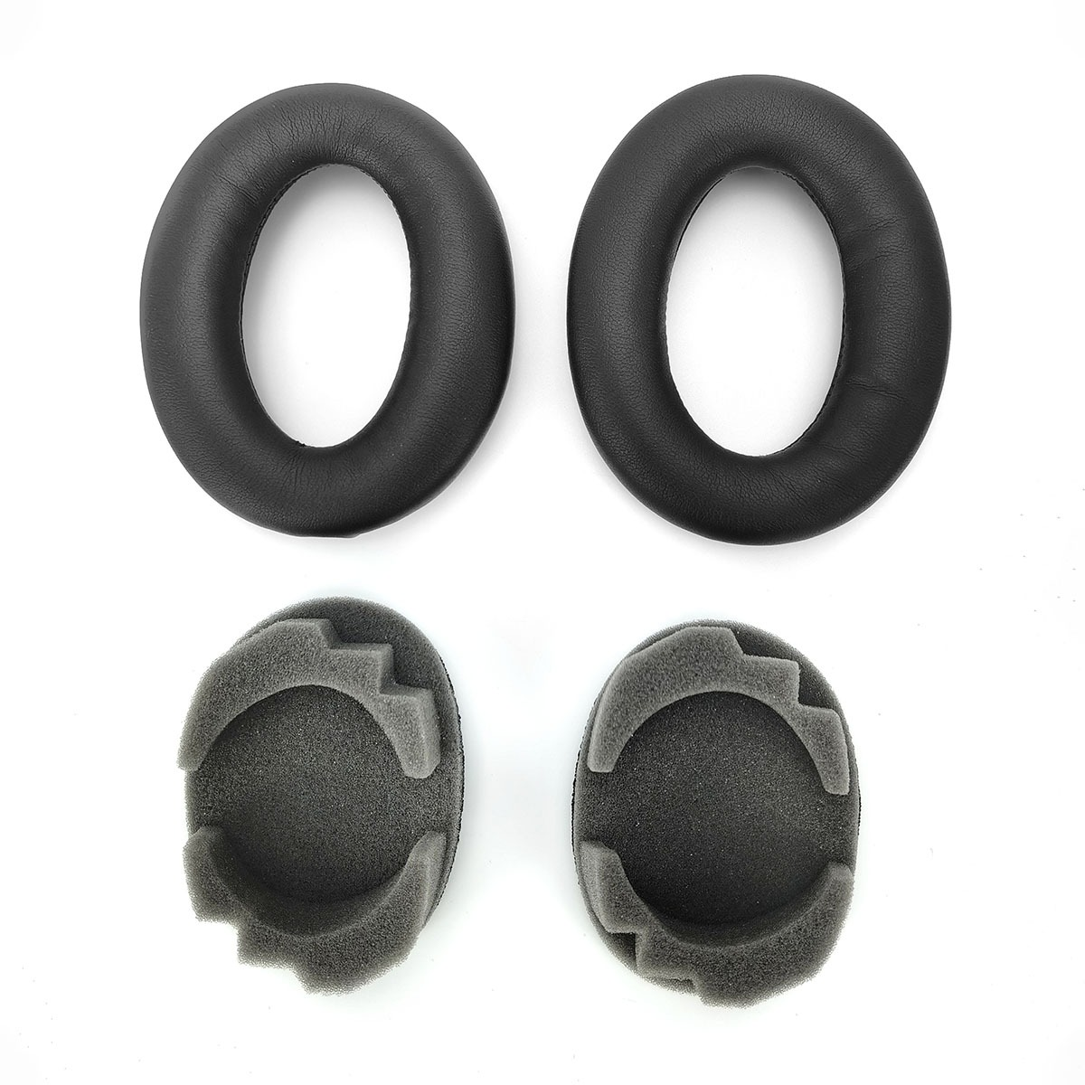 Dwie czarne poduszki na uszy i dwa piankowe wkładki na białym tle.