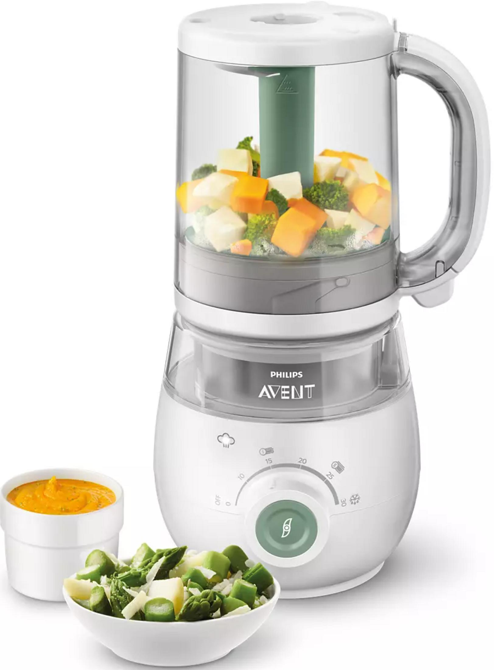 Un robot per alimenti per bambini bianco con verdure tritate, accanto a una ciotola di verdure tritate e una ciotola di purè.