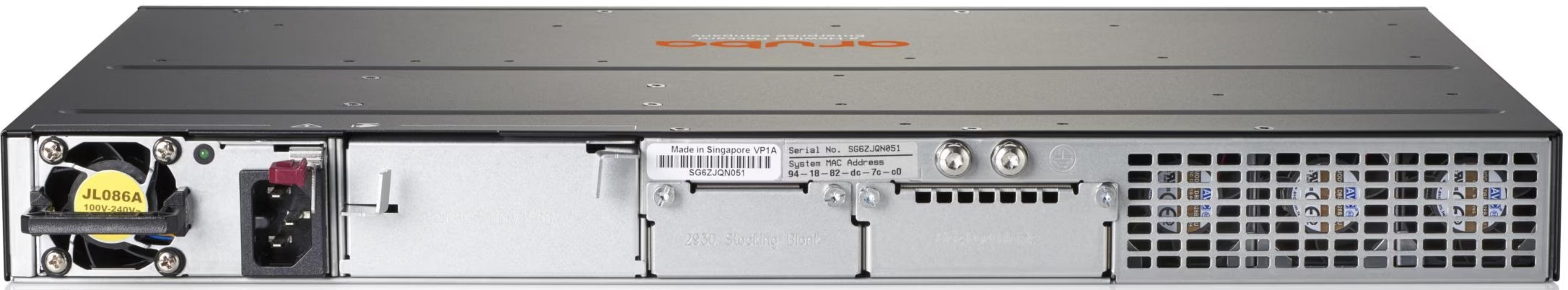 Tył szarego przełącznika sieciowego z wentylatorem, portami i kratkami wentylacyjnymi.