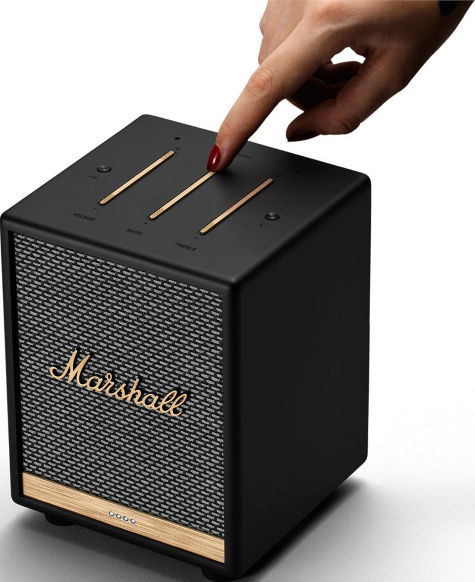 Una mano con esmalte rojo toca la parte superior de un altavoz Marshall negro.