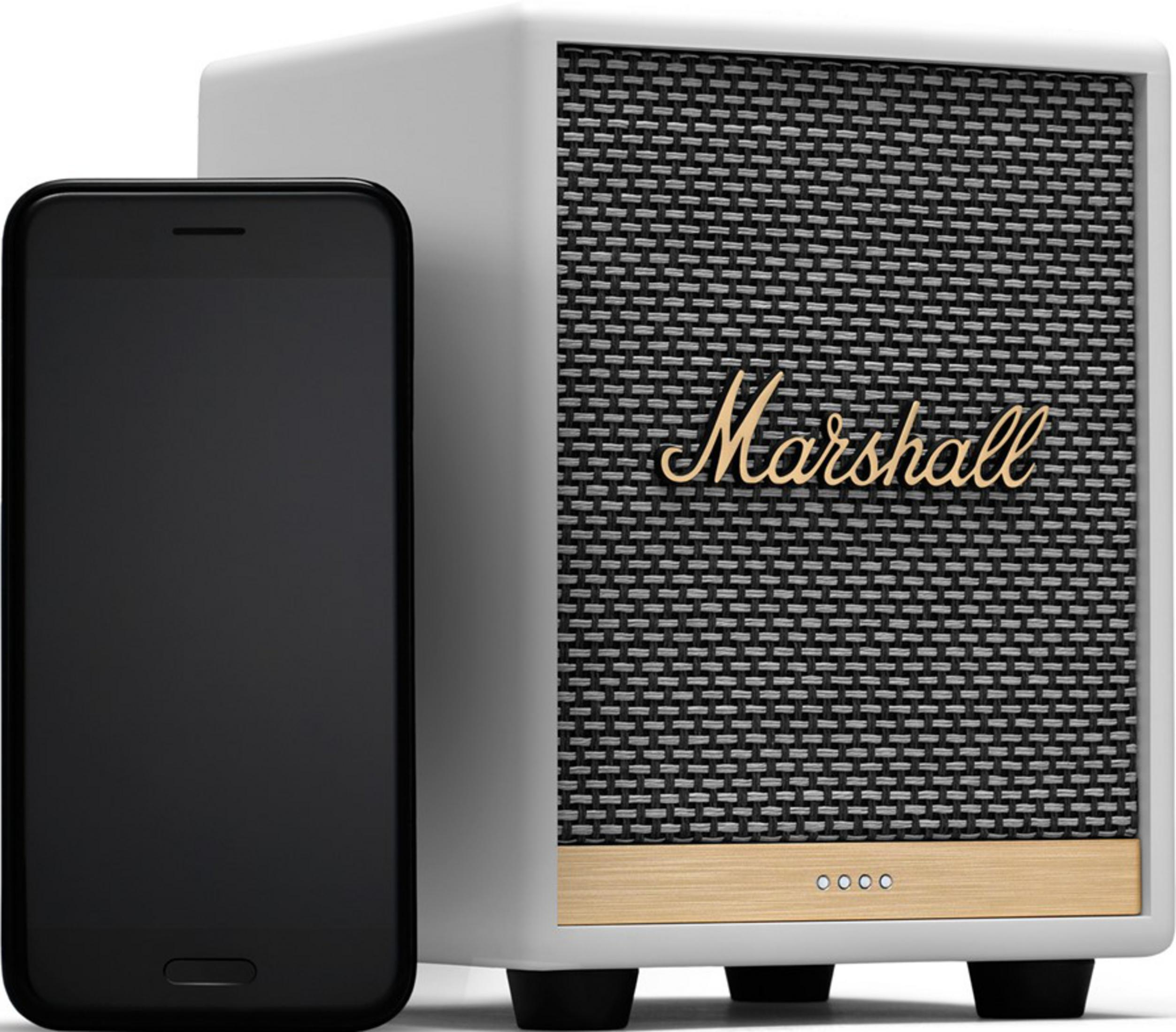 Un smartphone negro está junto a un altavoz Marshall blanco con rejilla negra.