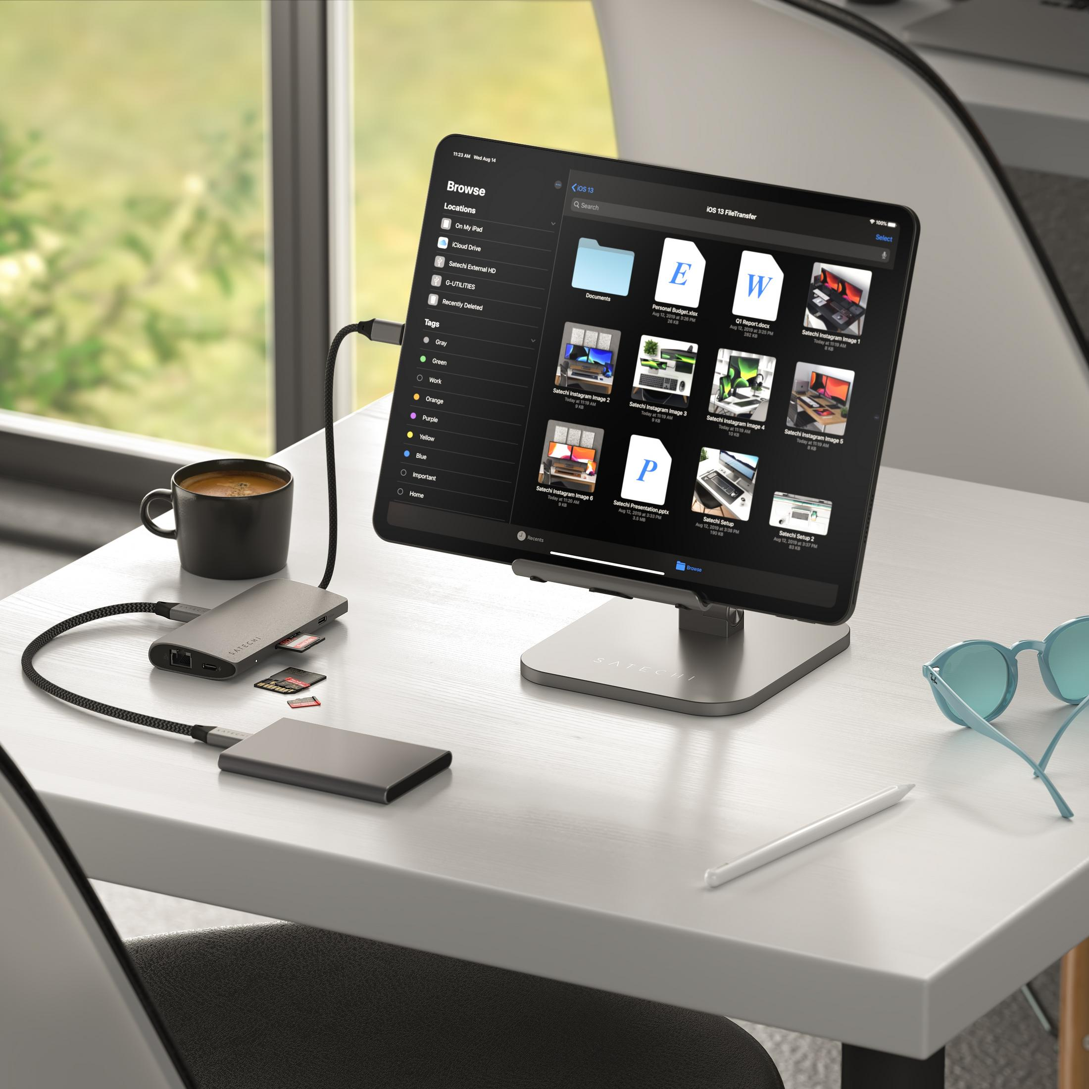 Ein Tablet mit Dateimanager-App, Hub, SD-Karte und Kaffeetasse auf einem Schreibtisch.