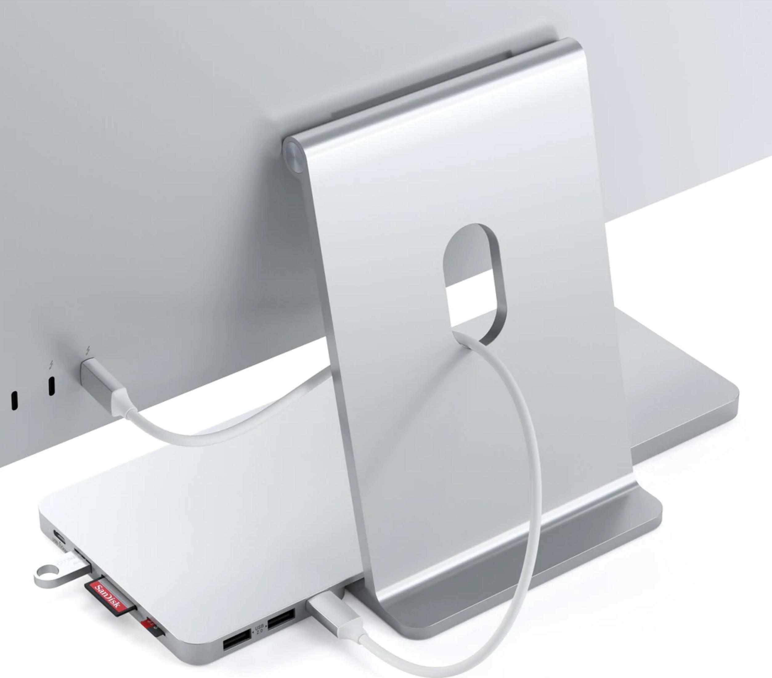 Un hub USB-C argentato con scheda SD e chiavette USB collegate al computer.