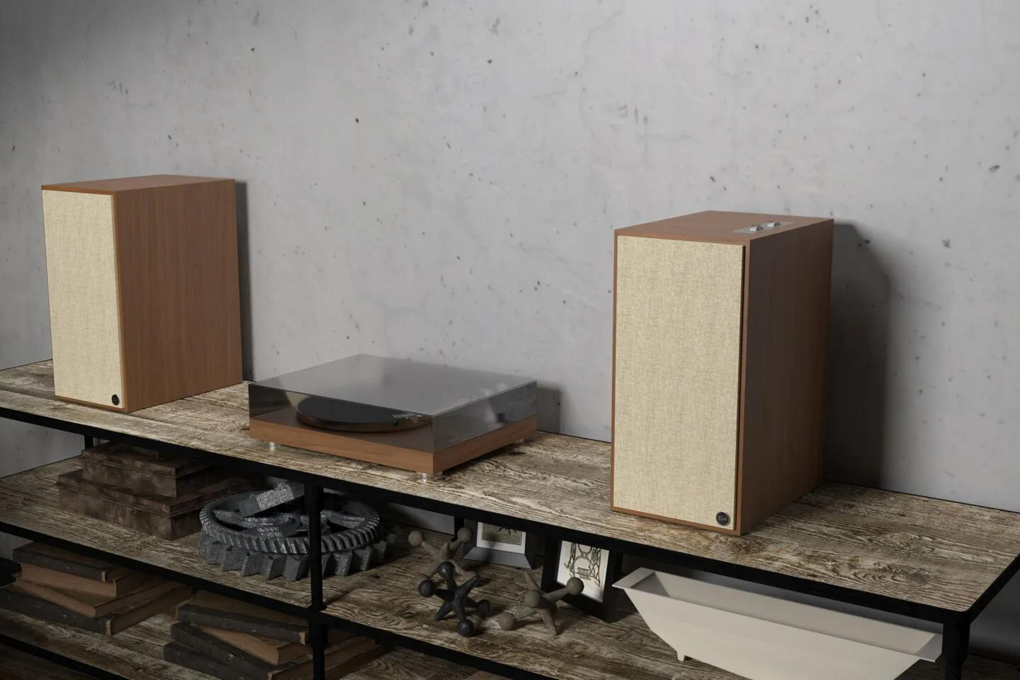 Holzregal mit Plattenspieler und zwei Lautsprechern daneben.