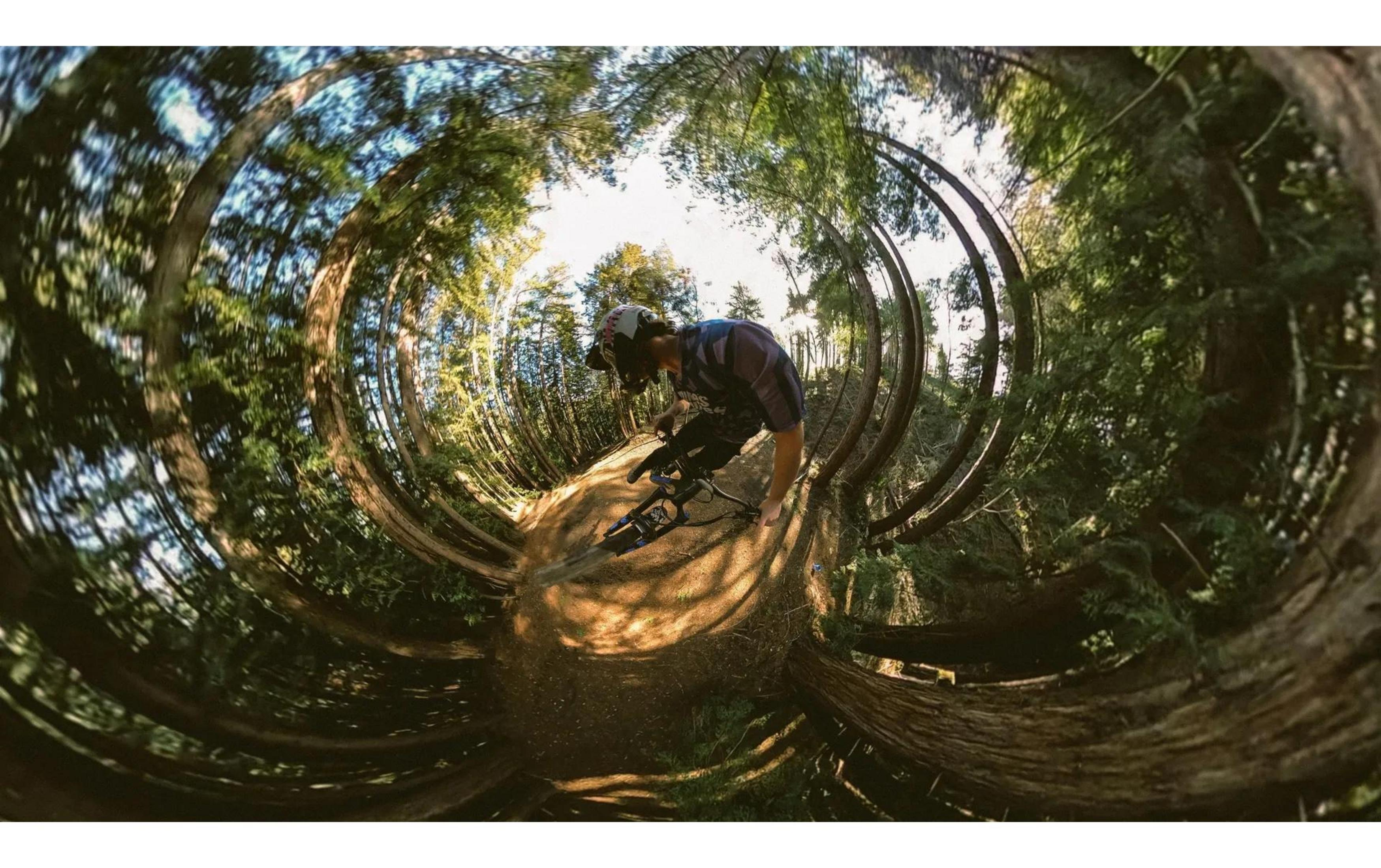 Un uomo in mountain bike su un sentiero nel bosco.