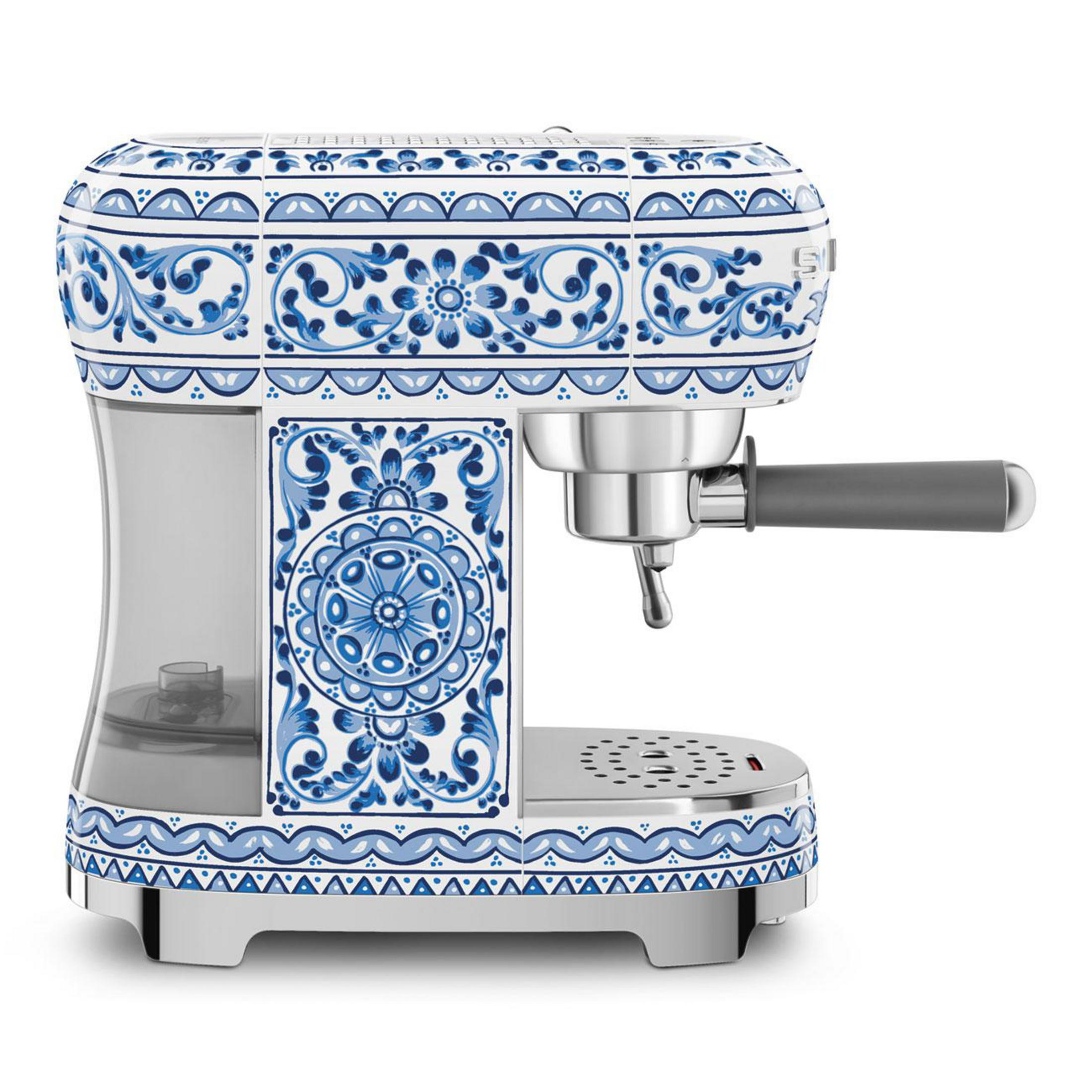 Eine weiße Espressomaschine mit blauem, barockem Muster, auf weißem Hintergrund.