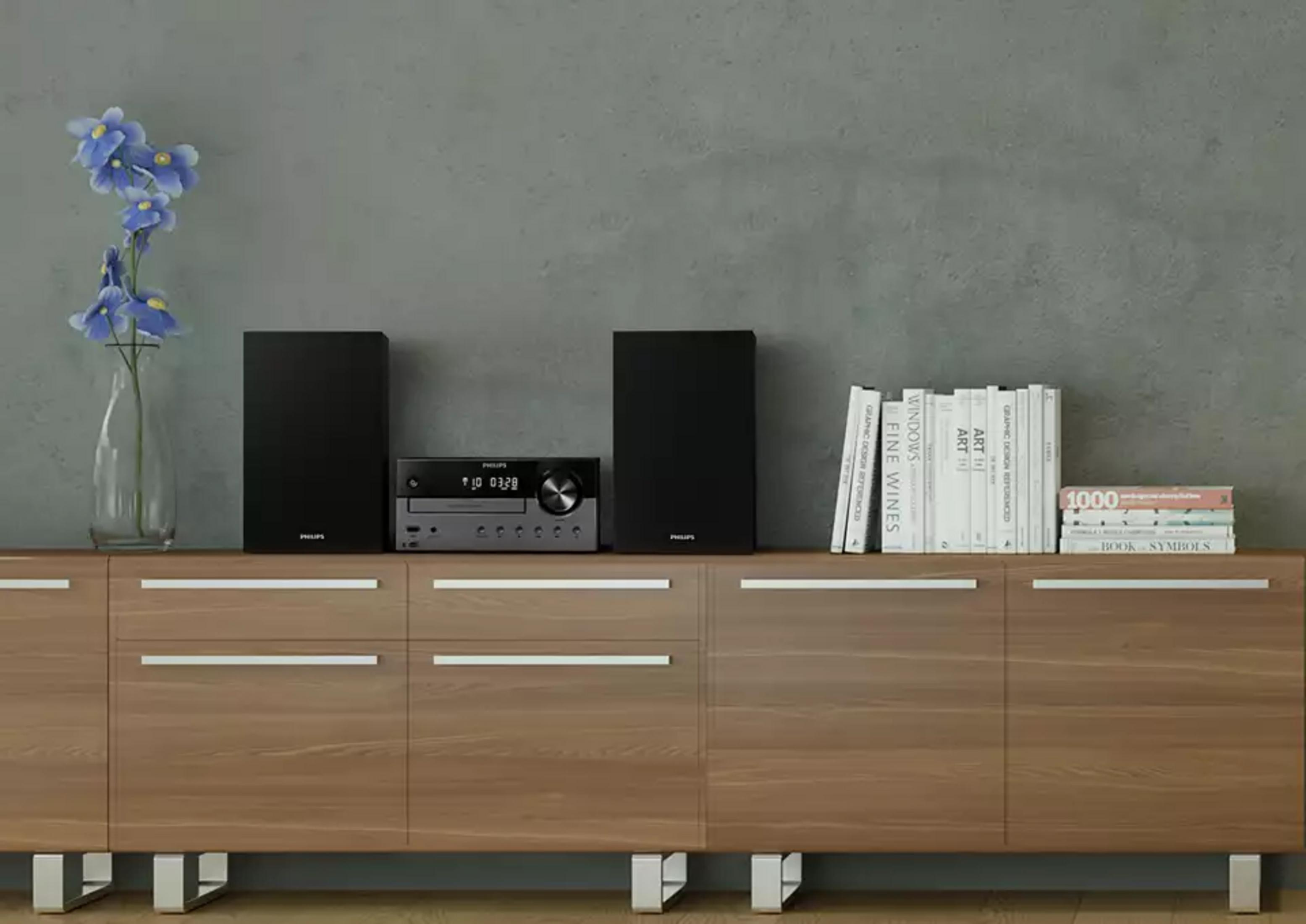 System stereo Philips z dwoma czarnymi głośnikami, odtwarzaczem CD i książkami.