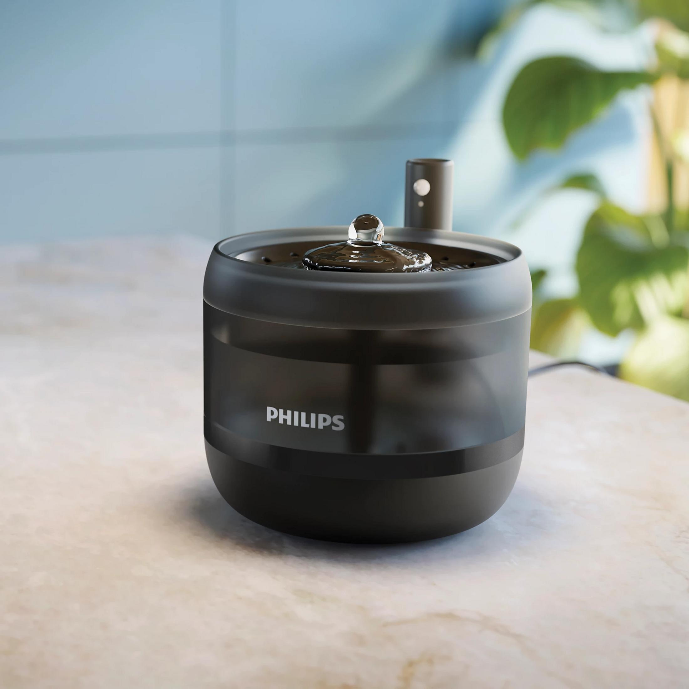 Ein dunkler Philips Wasserspender mit sprudelndem Wasser auf einer Marmoroberfläche.