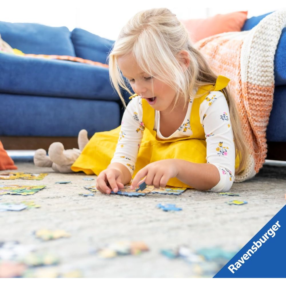 Blond dziewczynka w żółtej sukience bawi się puzzlami na dywanie.