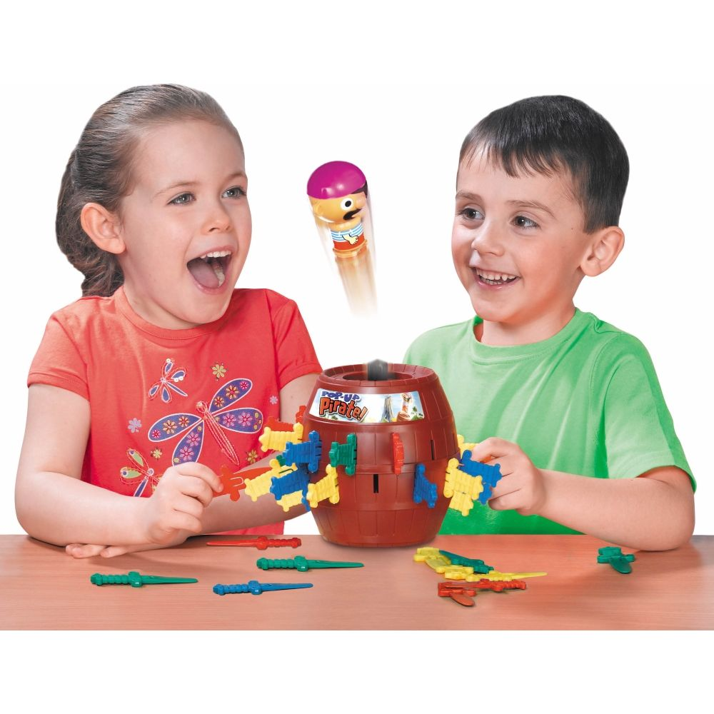 Kinder spielen Pop-Up-Pirat mit einem braunen Fass und bunten Schwertern.