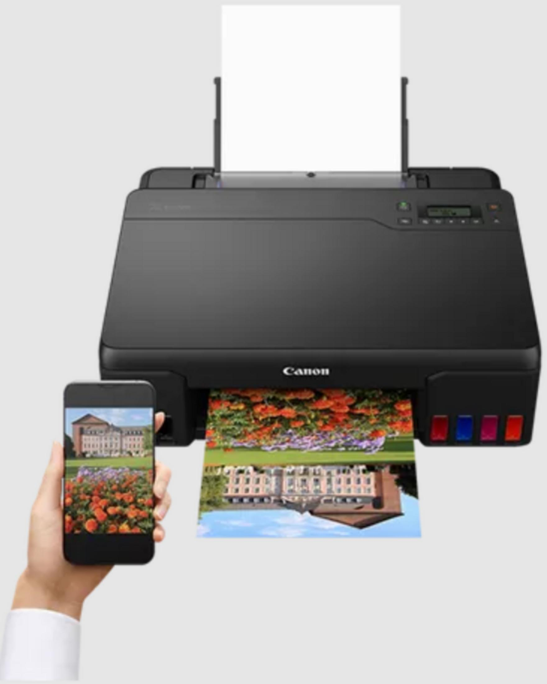 Czarna drukarka Canon drukuje obraz kwiatów i budynku.