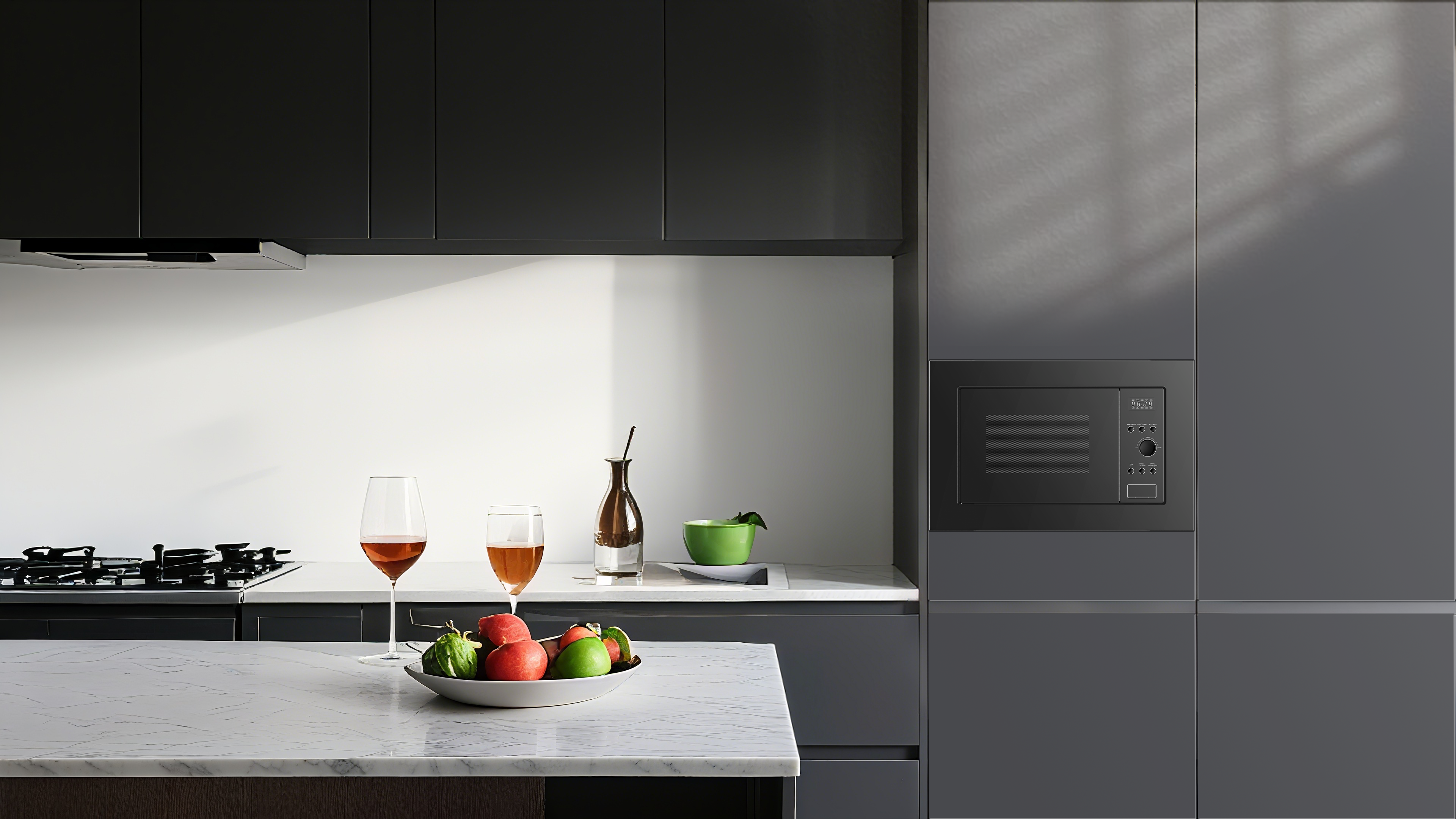 Moderne Küche mit Obstschale, Weingläsern und eingebauter Mikrowelle.