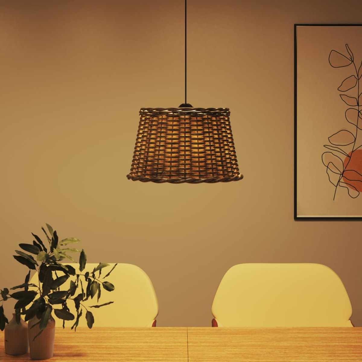 Eine Weiden-Pendelleuchte hängt über einem Holztisch mit Stühlen und Pflanzen.