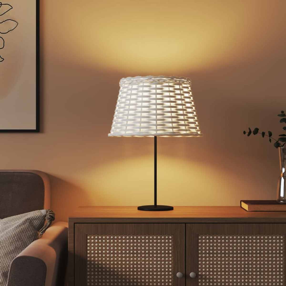 Eine weiße Korblampenschirm-Tischlampe steht auf einem Holzschrank.