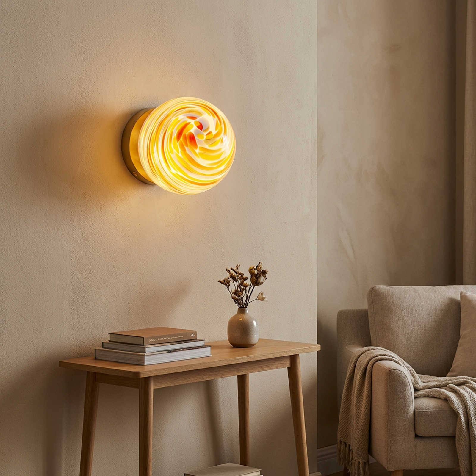 Una lámpara de pared con cristal ámbar arremolinado sobre una mesa de madera con libros y jarrón.