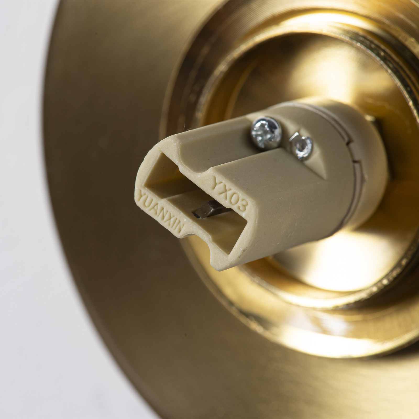 Primer plano de un conector dorado con inserción de plástico crema YUANXIN YXO3.