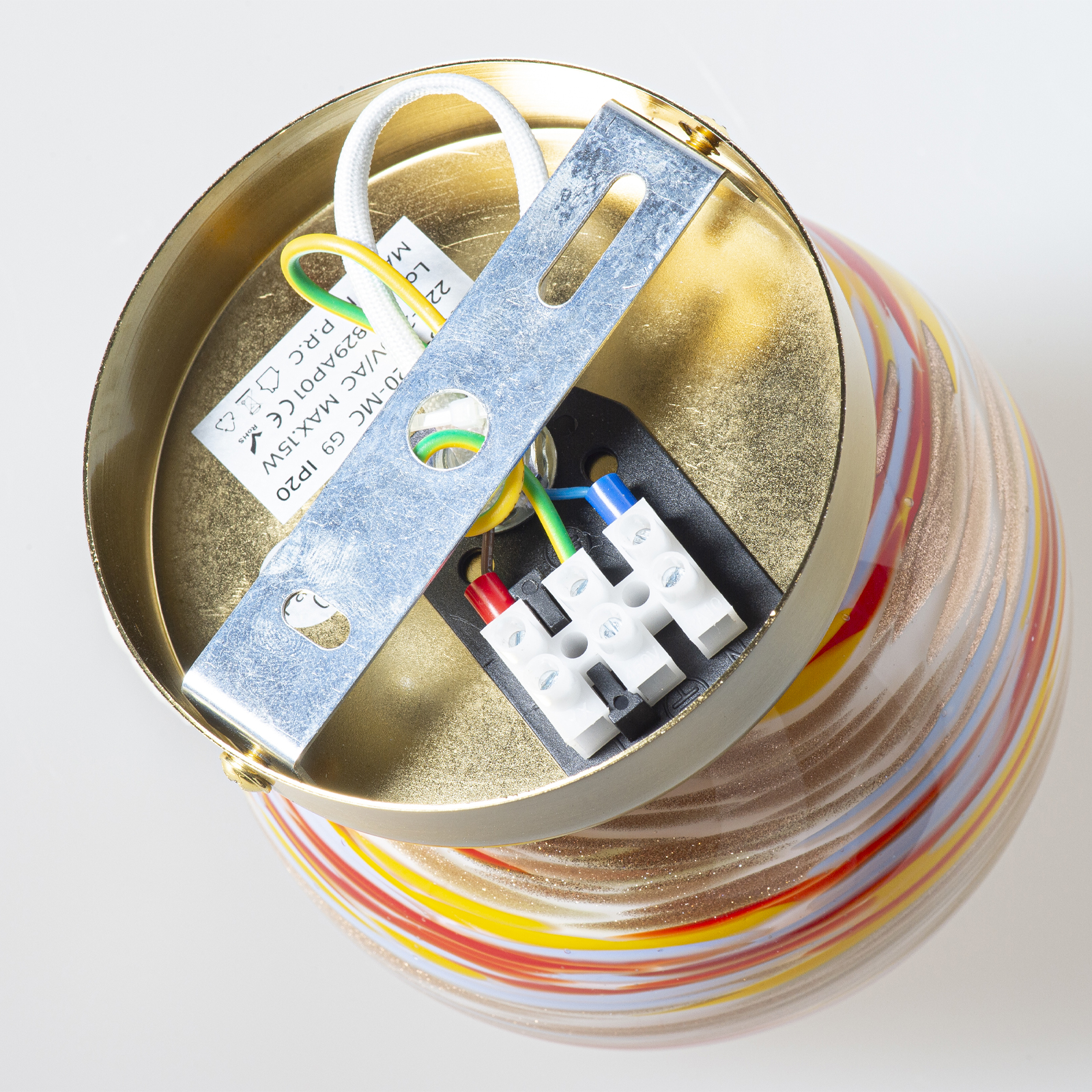 Lámpara de color latón con rayas coloridas y conexiones eléctricas.