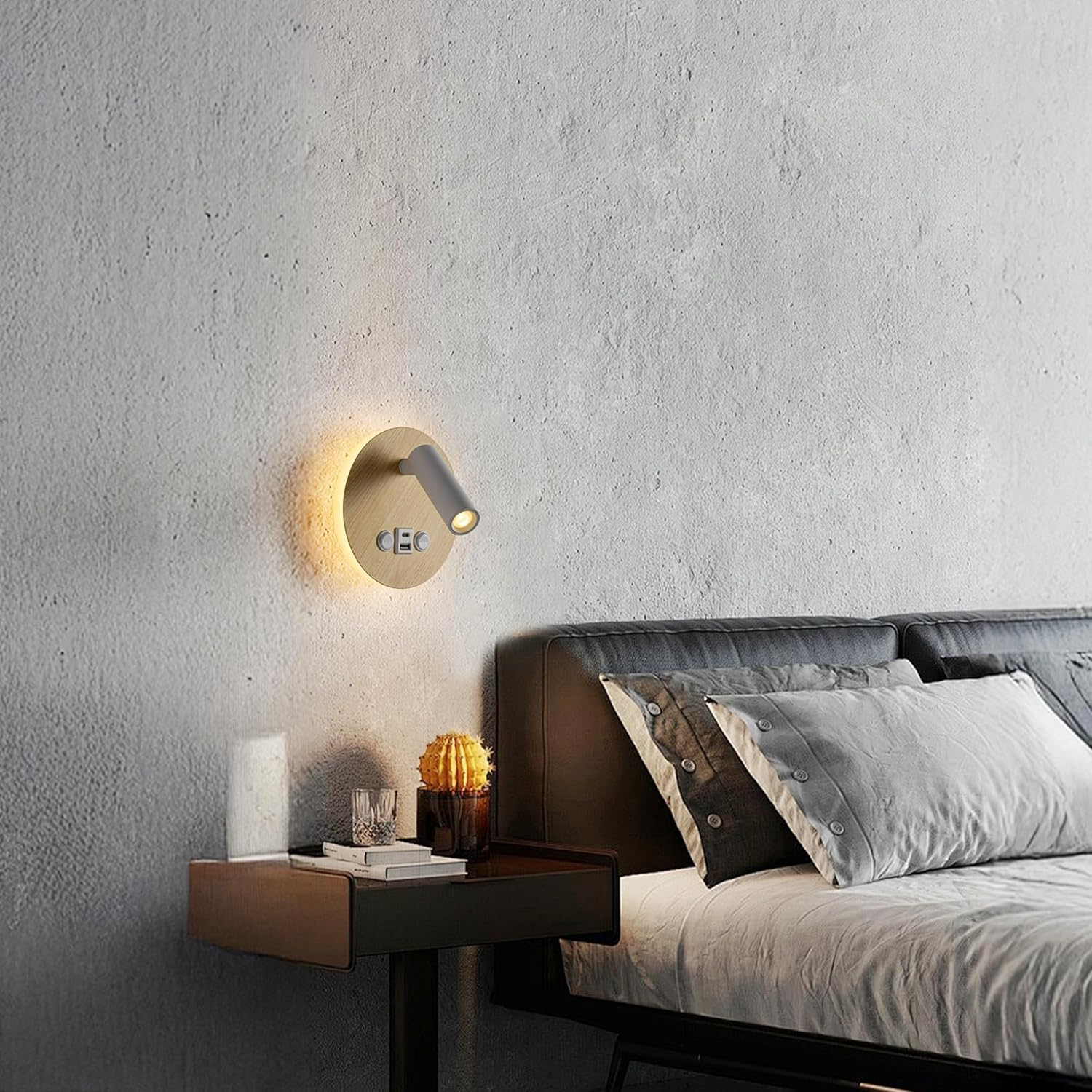 Lámpara de noche moderna en pared texturizada sobre mesita de noche con libros, vaso y cactus.