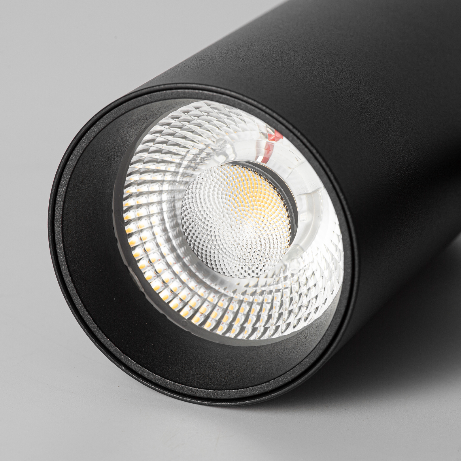 Foco cilíndrico negro con LEDs y reflectores visibles.