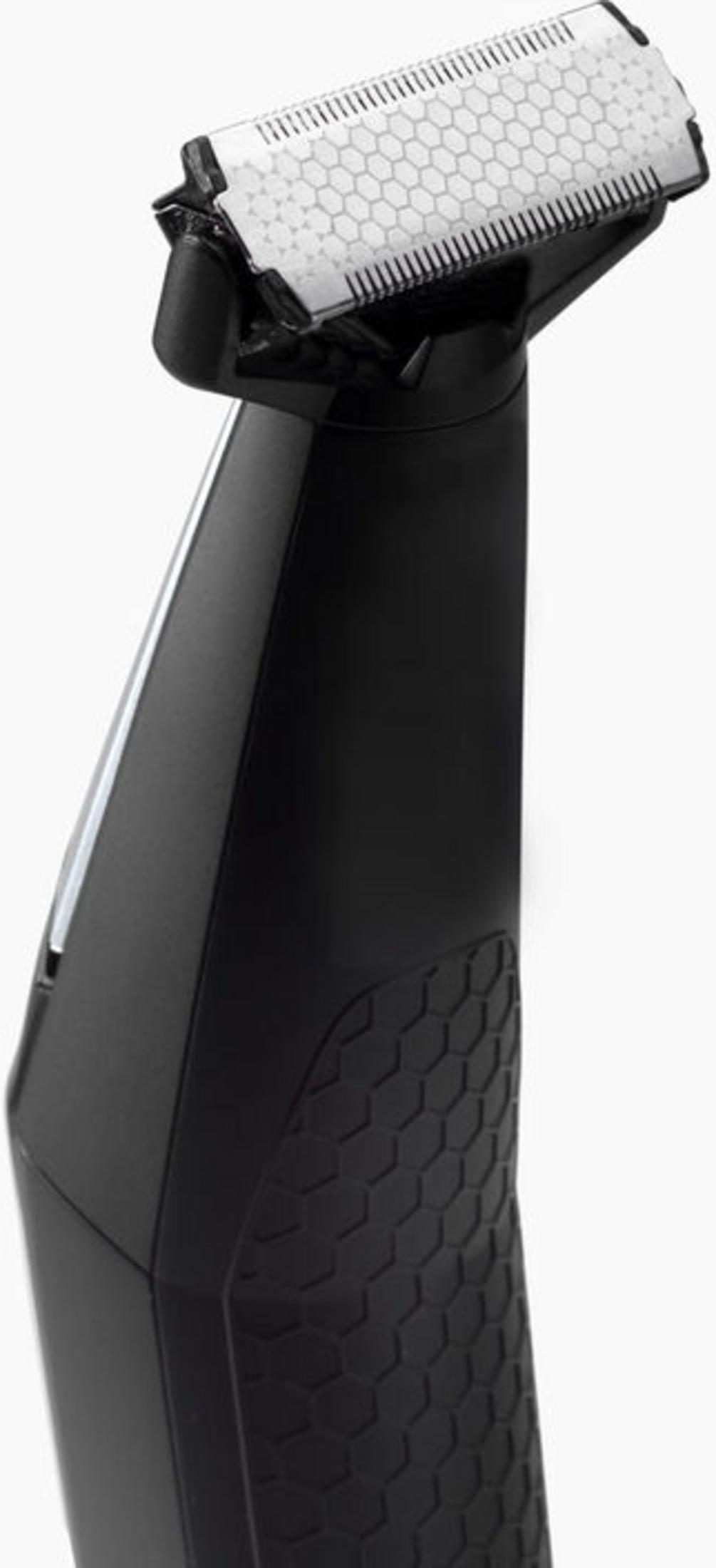 Zbliżenie czarnej maszynki z srebrną folią i szczegółowym wzorem uchwytu.