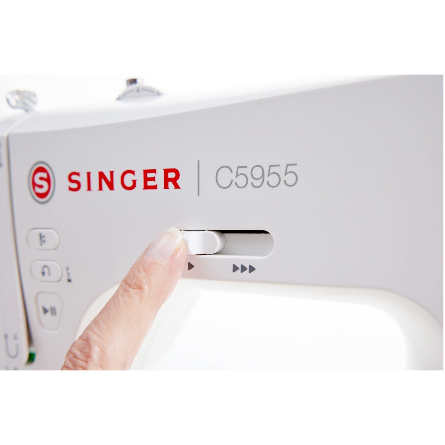 A fingertip slides a white slider on a Singer sewing machine.