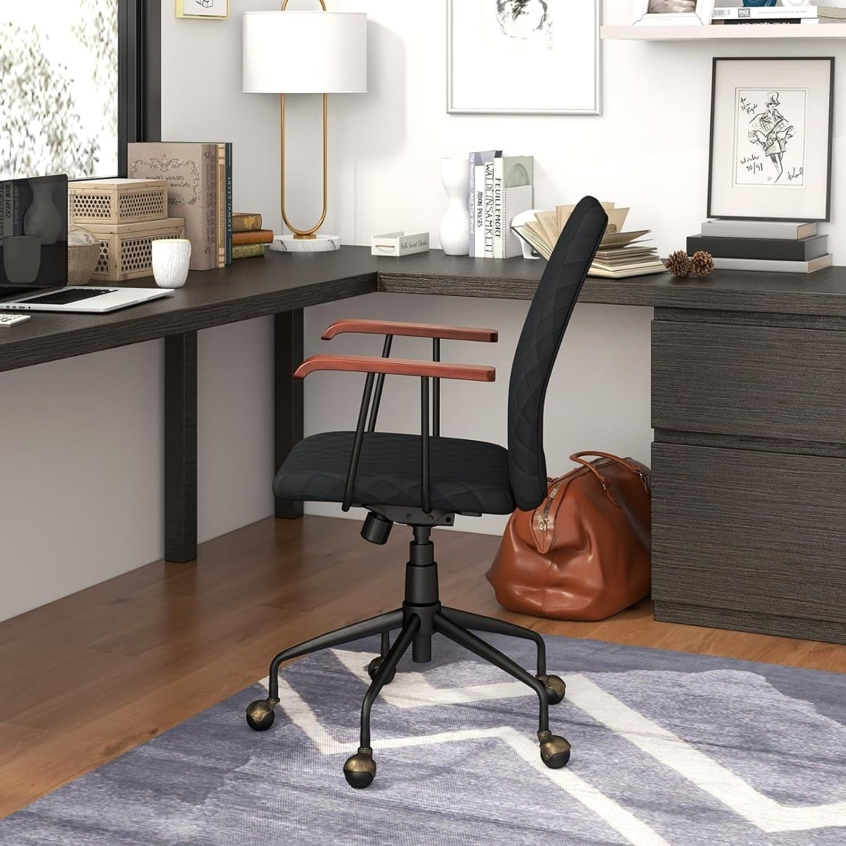 Een zwarte bureaustoel met houten armleuningen staat op een kleed naast een bureau.