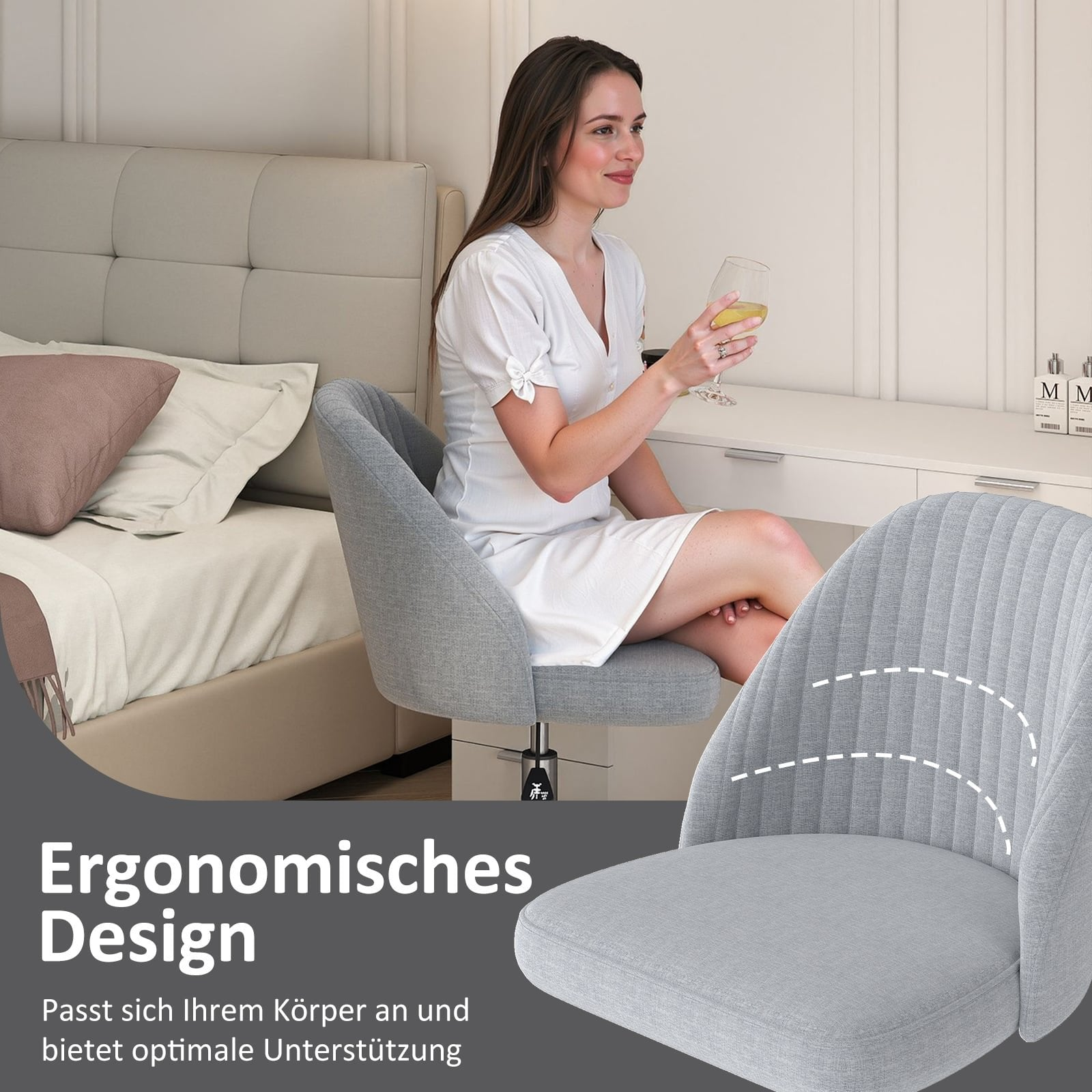 Woman in white dress sits on grey chair with wine glass, beside bed and desk.