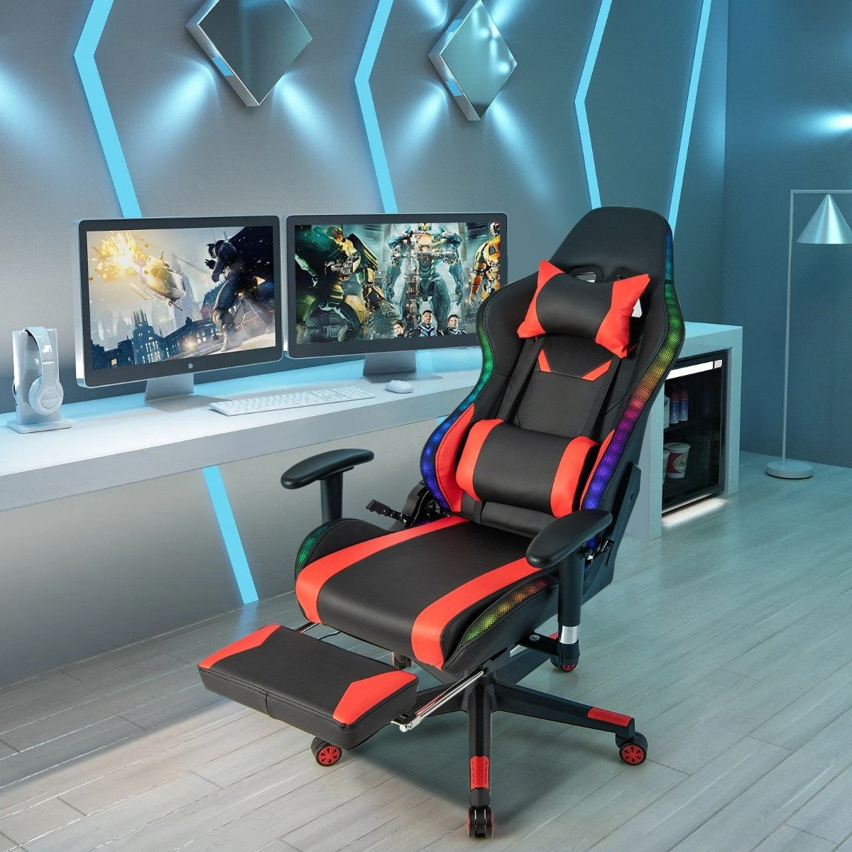 Una silla gamer negra con detalles rojos e iluminación RGB frente a dos monitores de ordenador.