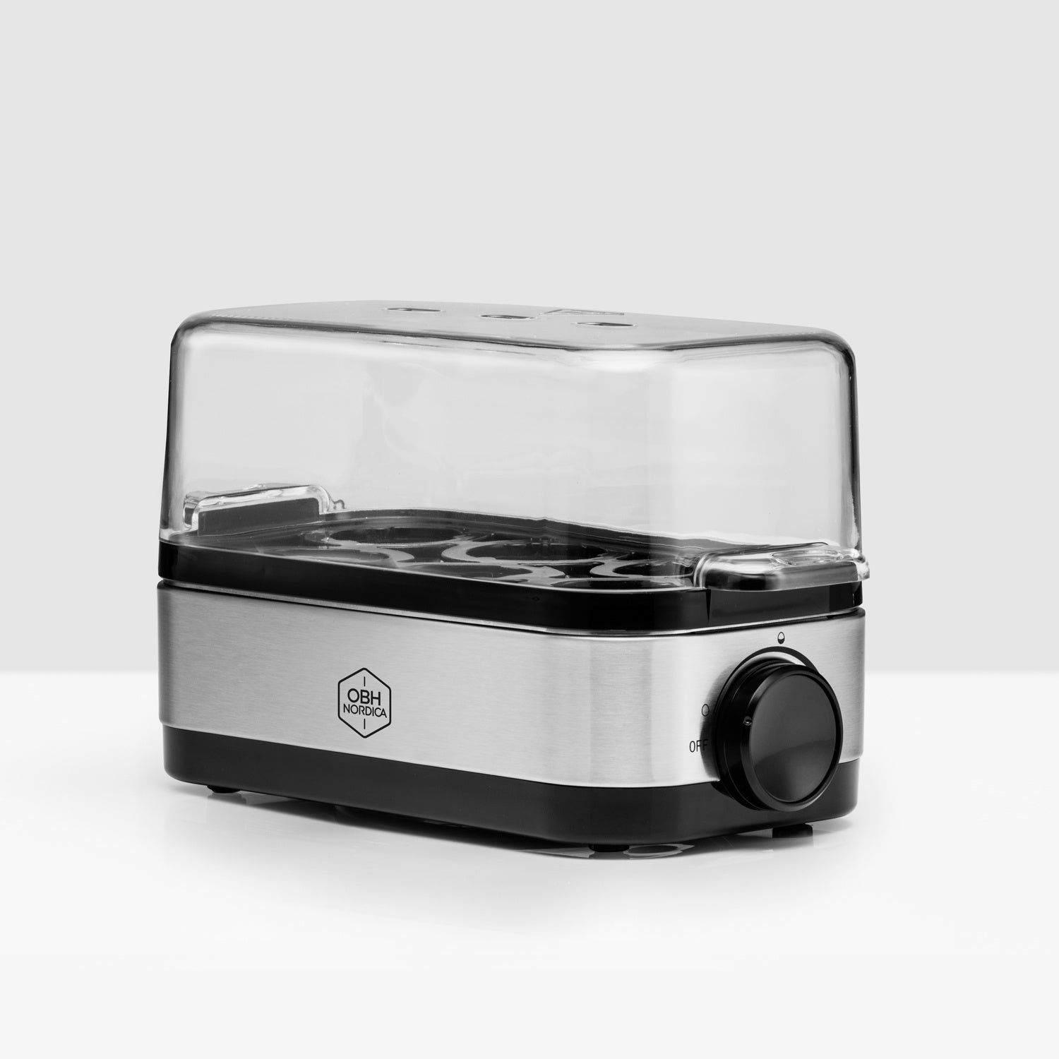 A silver egg cooker with a black lid and a dial on a light background.