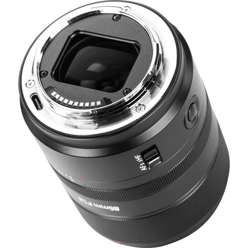 Primo piano di un obiettivo per fotocamera nero con attacco argentato. Interruttore AF/MF visibile.