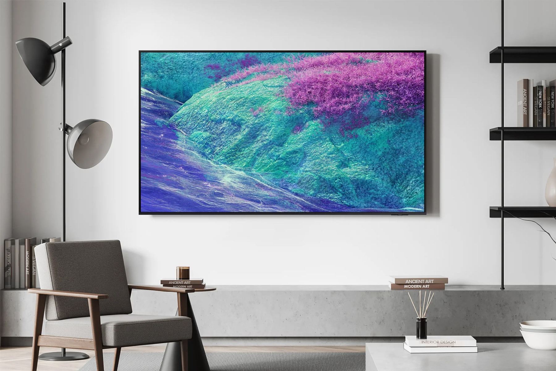 Nowoczesny salon z dużym telewizorem z płaskim ekranem wyświetlającym krajobraz fioletowych i turkusowych wzgórz.