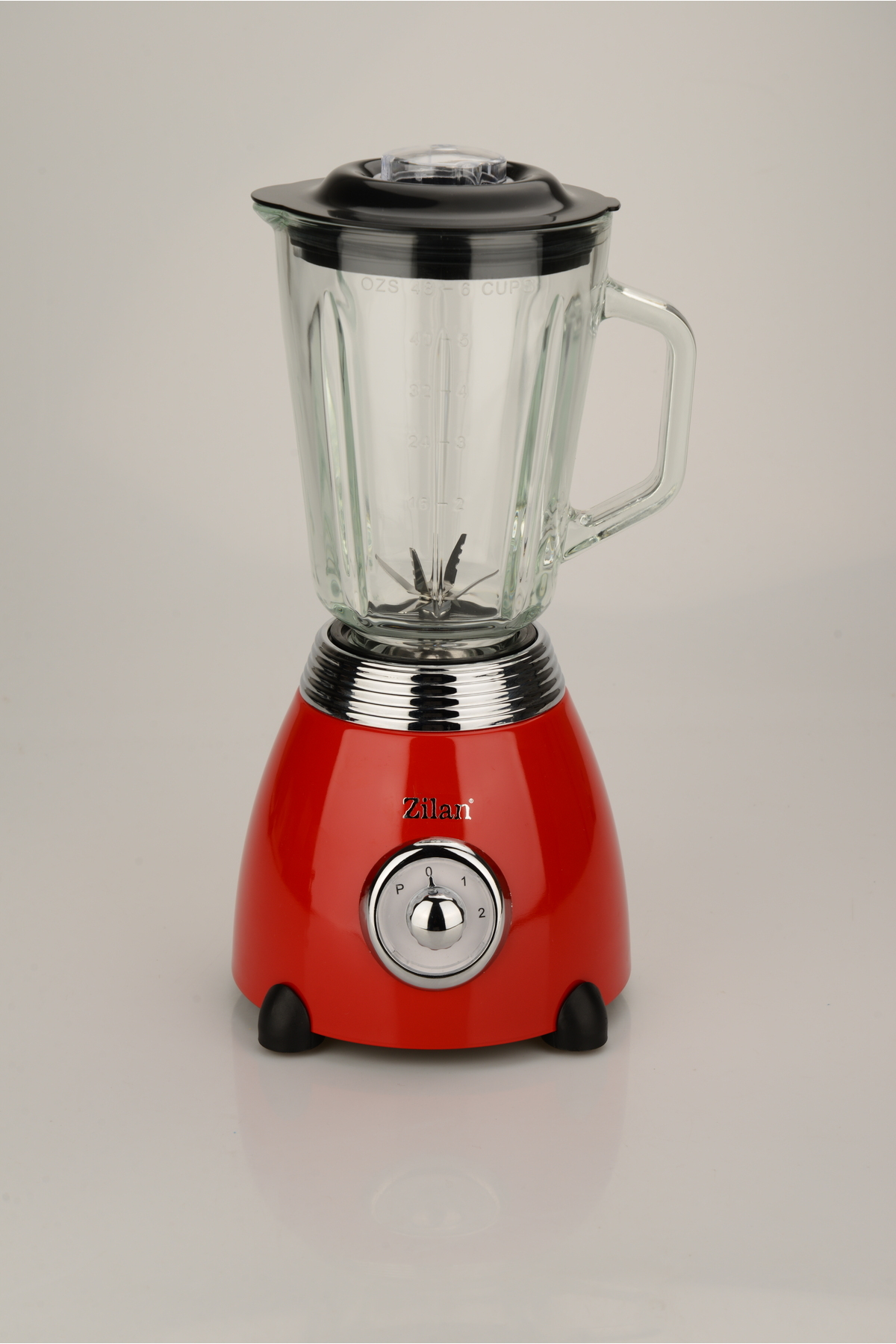 Koyu arka plan üzerinde cam sürahi ve siyah kapaklı kırmızı blender.