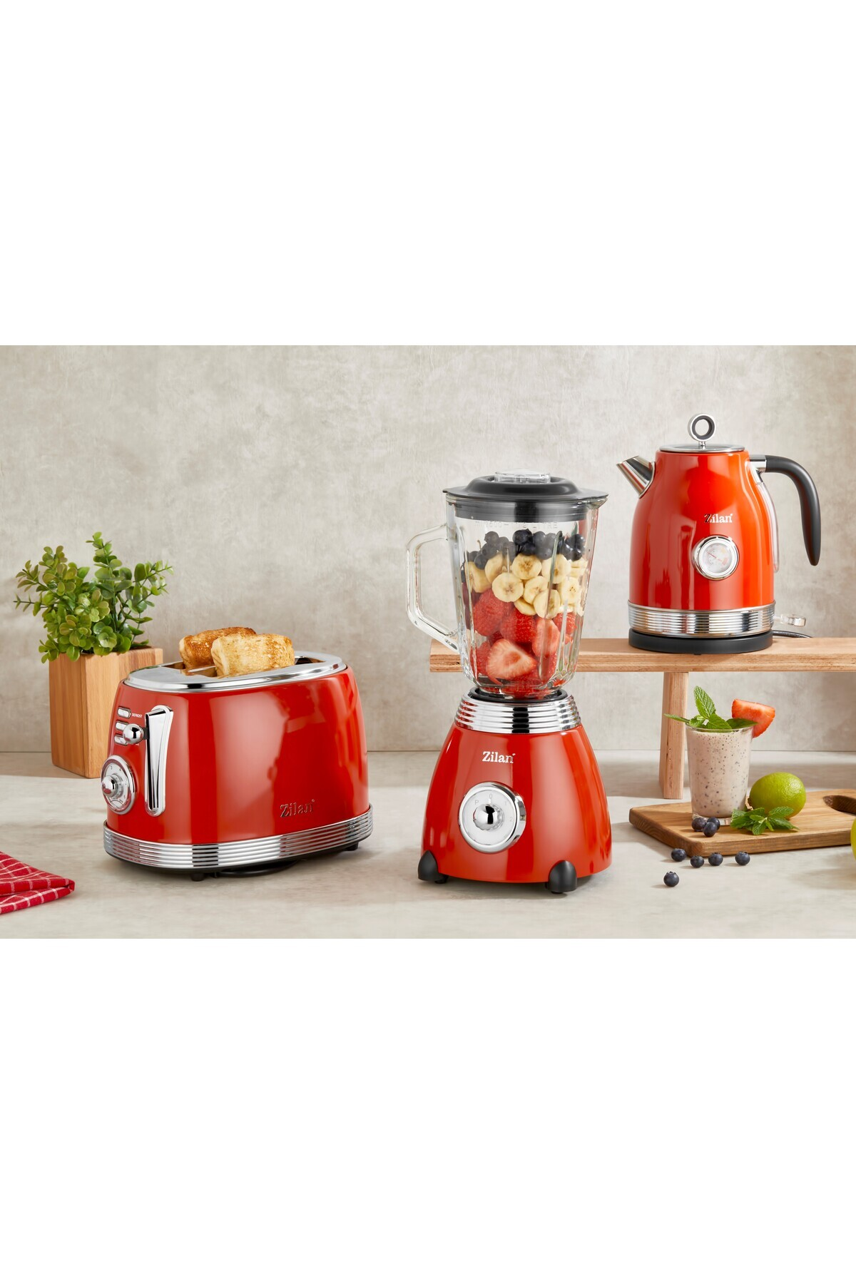 Kırmızı mutfak aletleri: tost makinesi, meyveli blender, su ısıtıcısı, smoothie.