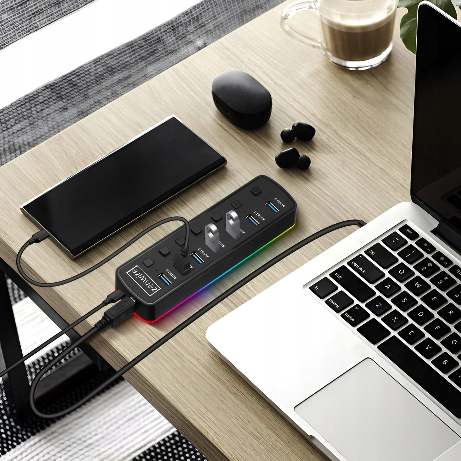 Czarny koncentrator USB z tęczowymi diodami LED, podłączony do laptopa i smartfona.