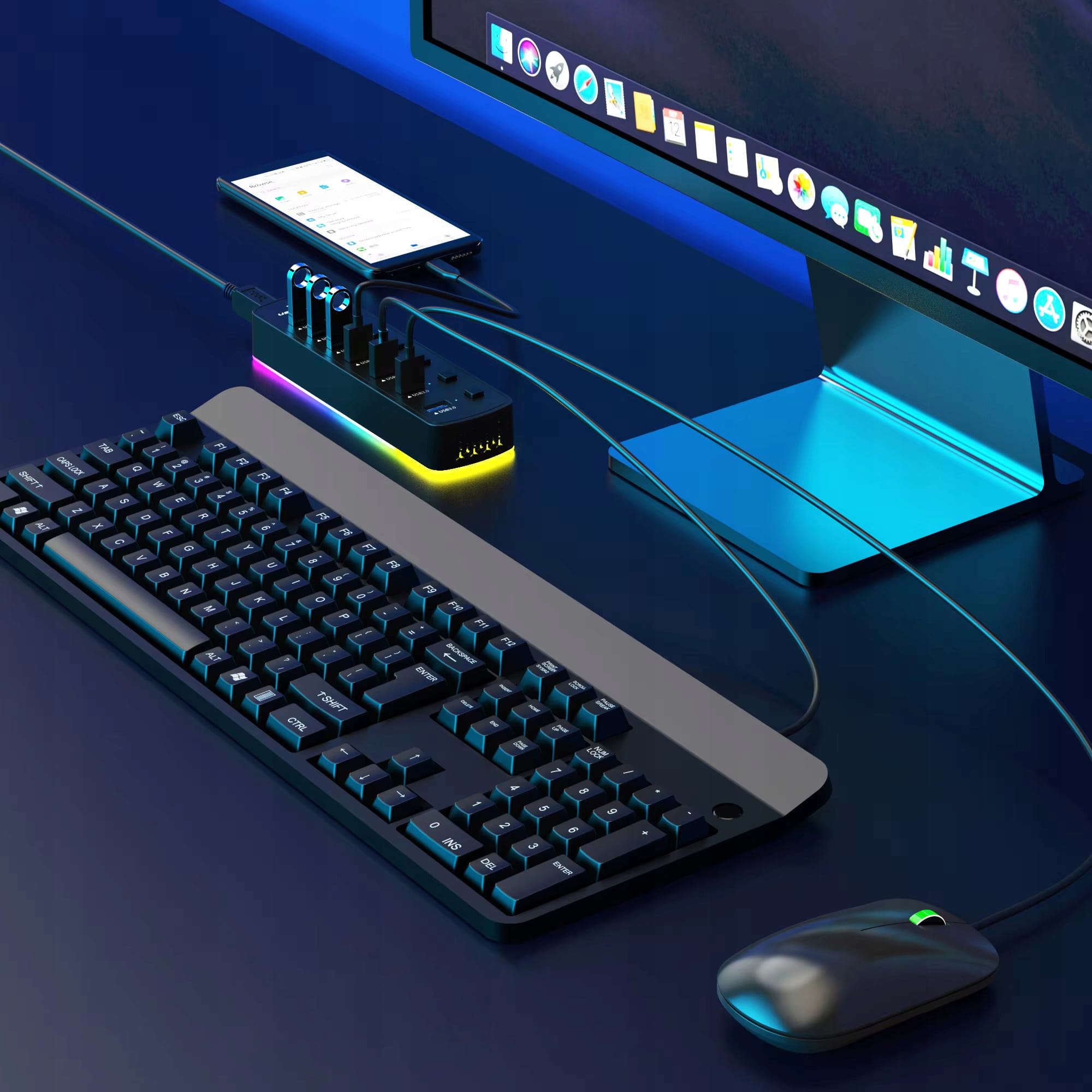 Czarna klawiatura, mysz, koncentrator USB i smartfon przed monitorem.