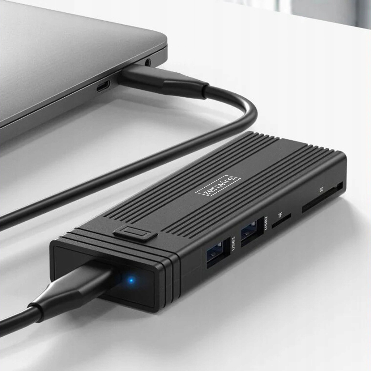 Czarny koncentrator USB-C podłączony do laptopa, z wieloma portami.