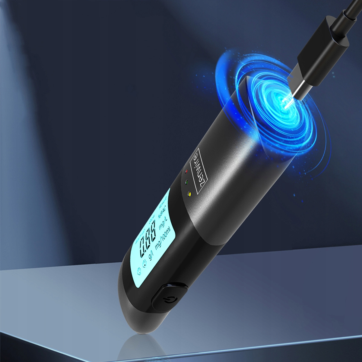 Czarny alkomat z niebieskim światłem, ładuje się przez USB.