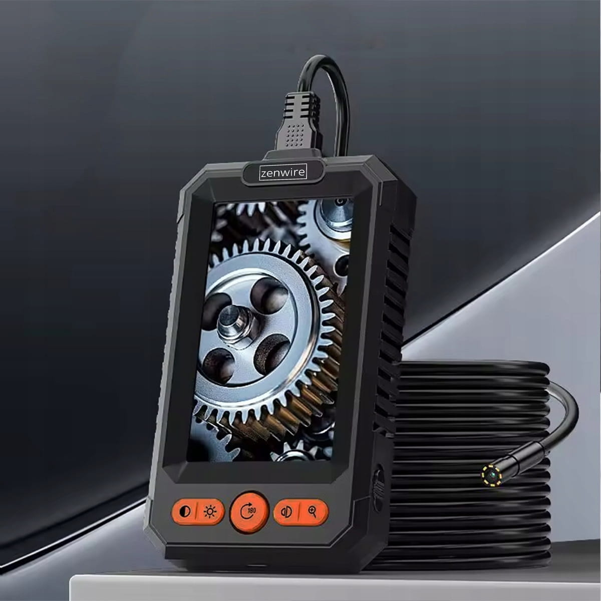 Cyfrowy endoskop z ekranem pokazuje zębatki. Obok leży czarny wąż.