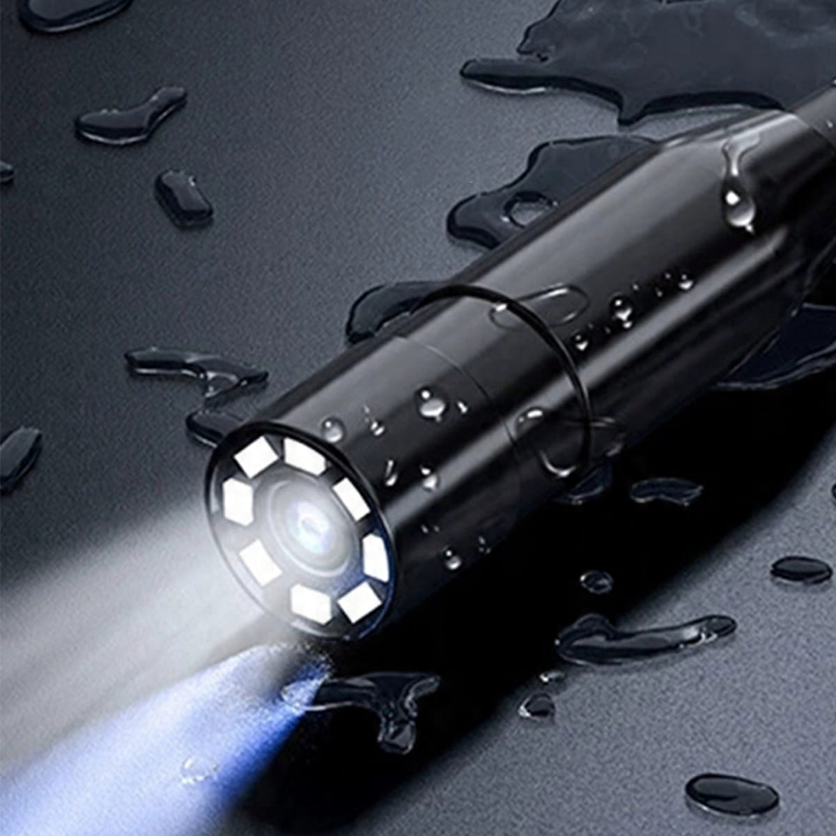 Czarna endoskopowa kamera z diodami LED świeci na mokrym, ciemnym tle.